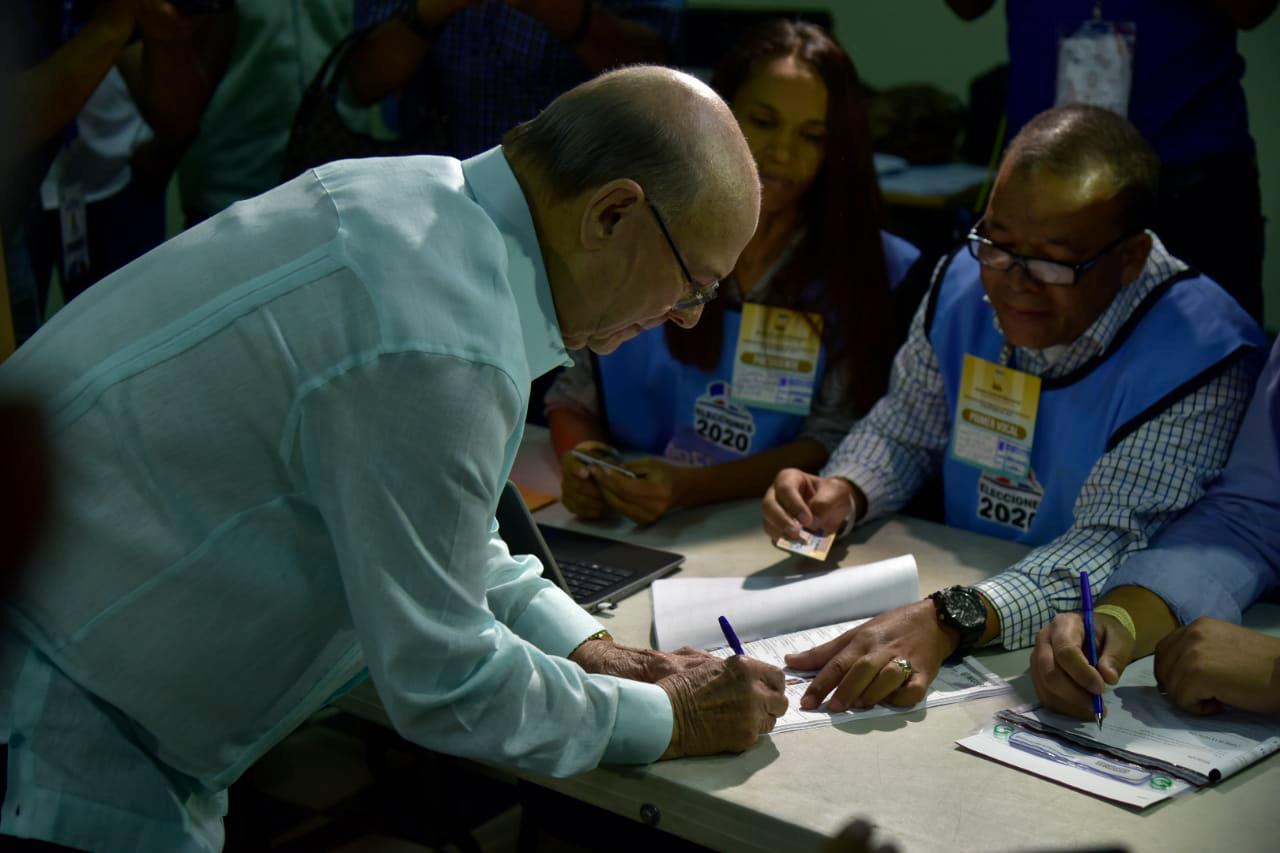 Hipólito Mejía firma después de ejercer el voto.
