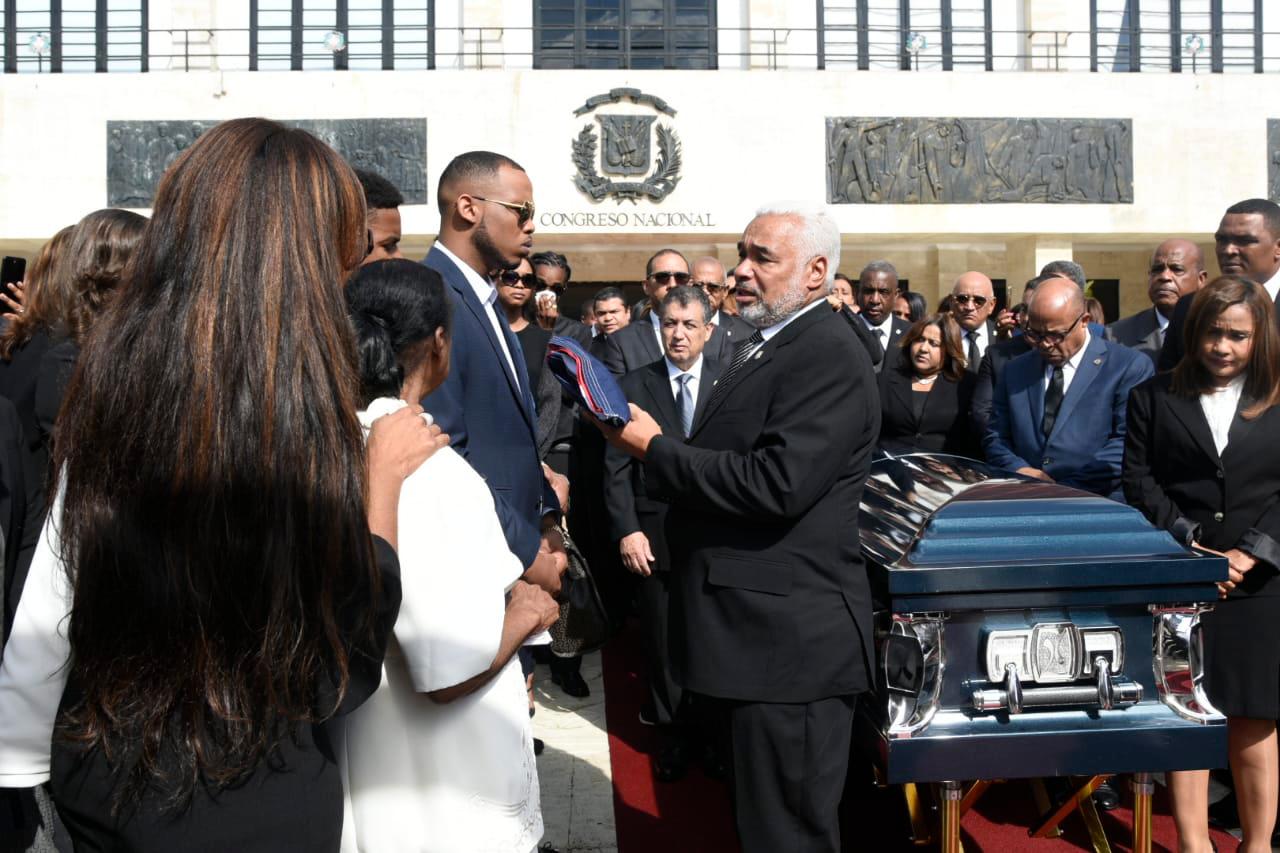 El presidente de la Cámara de Diputados entrega un ejemplar de la Bandera a familiares del legislador fallecido. 