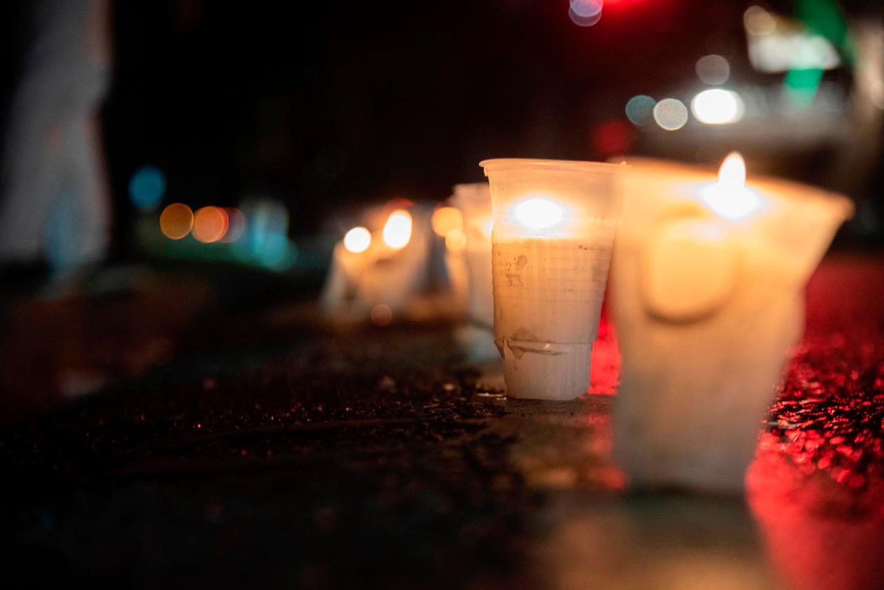 Manifestantes encienden velas. 