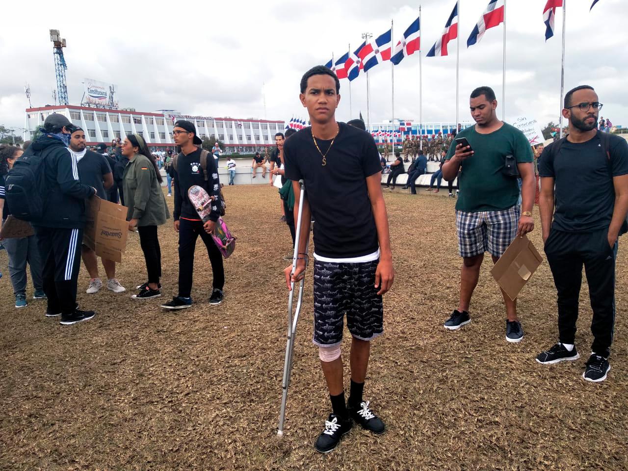 Joven con una muleta en la protesta frente a la Junta Central Electoral de este miércoles 19 de febrero de 2020.