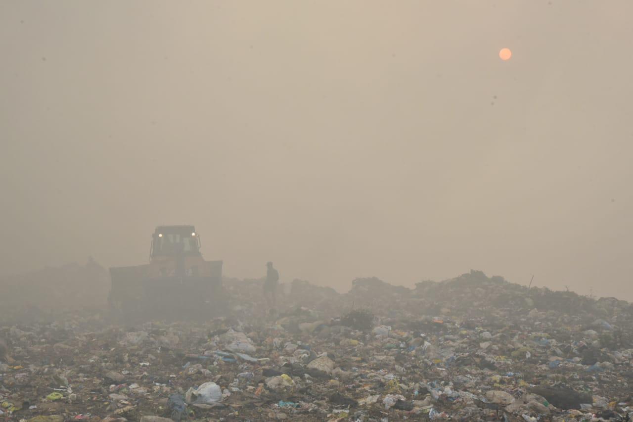 Una hombre y una retroexcavadora dentro de la humareda generada por el incendio en el vertedero de Duquesa este viernes 1 de mayor de 2020. (DIARIO LIBRE/JUAN MIGUEL PEÑA)