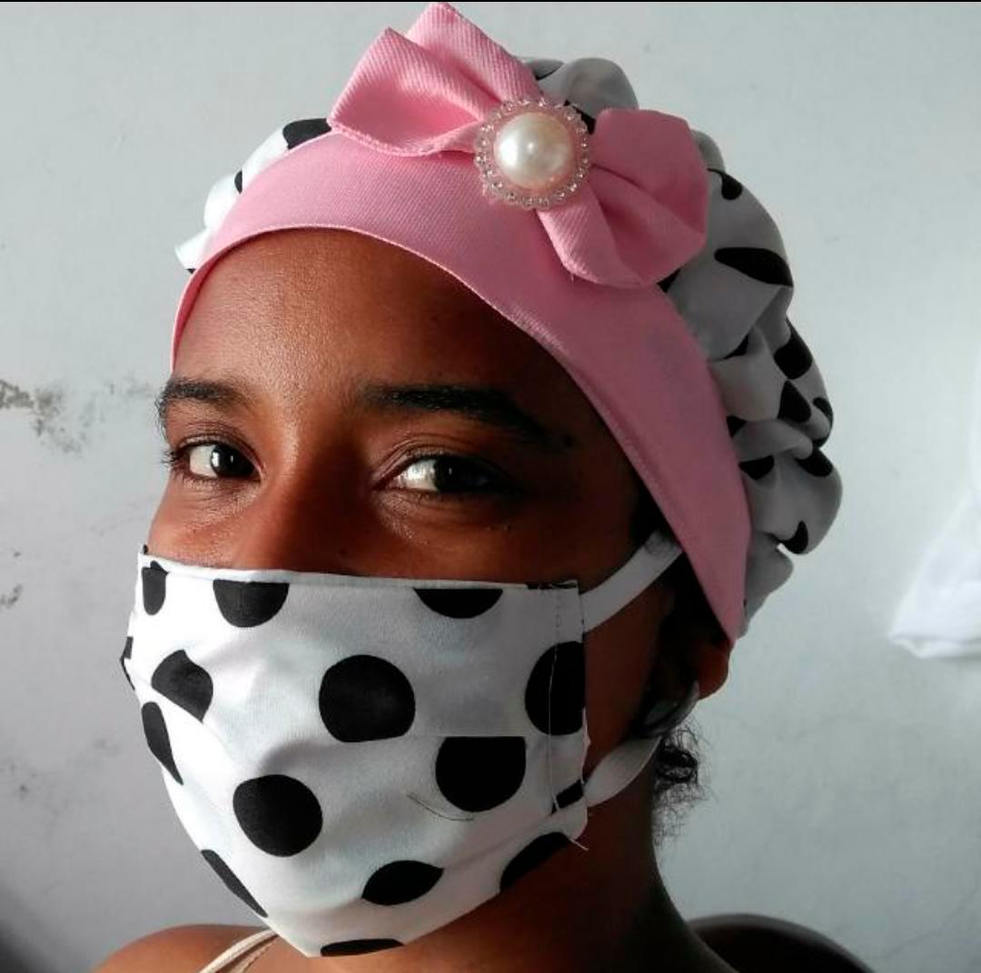 Dayrenis Díaz modela unos de los juegos de cubreboca y gorro.