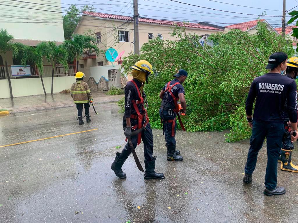Miembros del cuerpo de bombero de Punta Cana trabajan para despejar las vías. 