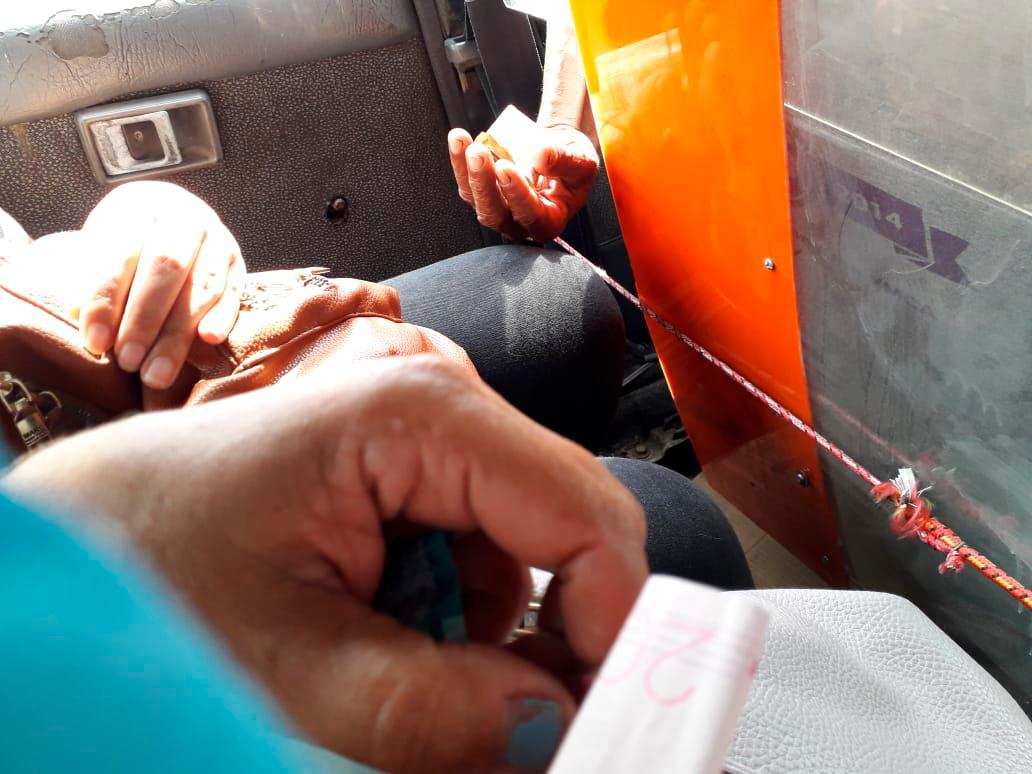 El chofer recogiendo el dinero de los pasajeros.