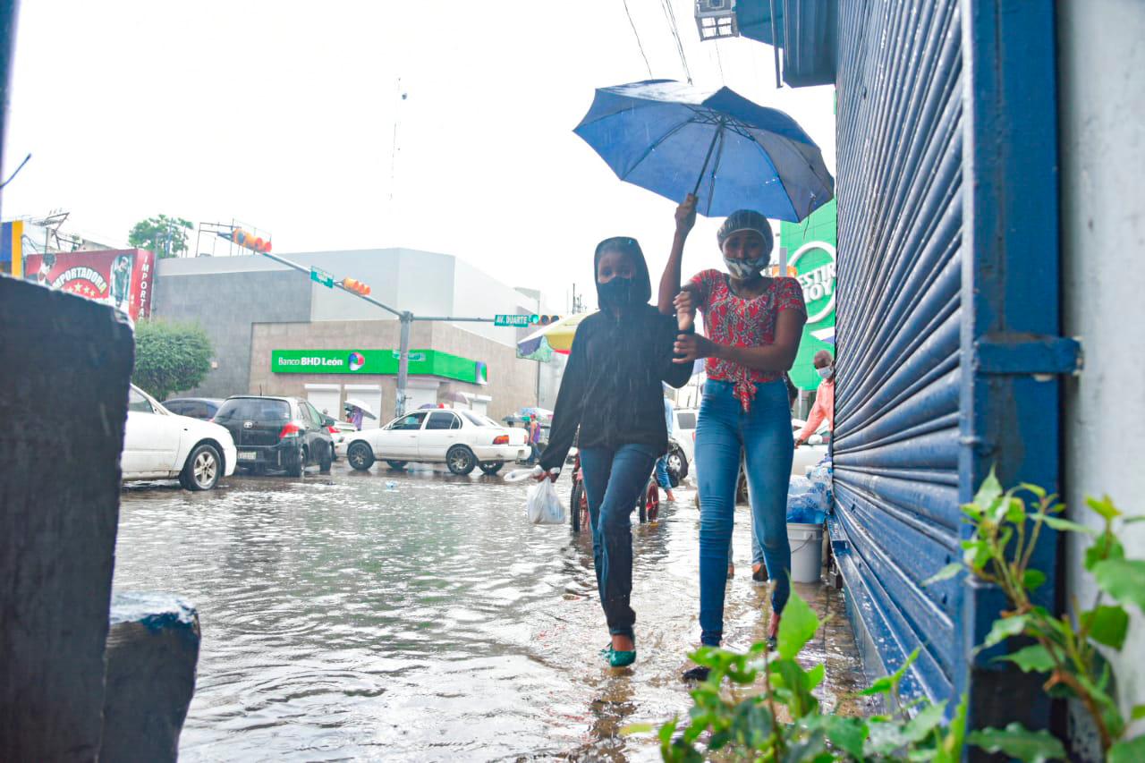 Las aceras están colmadas de agua por lo que las personas casi no pueden circular. 