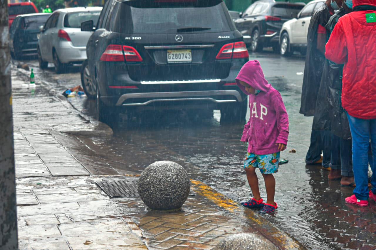 Un niño mientras intenta subir a la acera. 