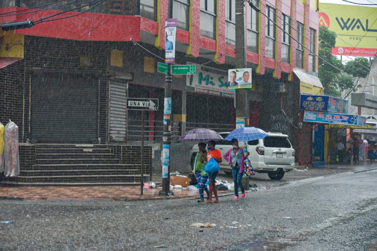 Aunque gran parte del día a estado lloviendo, las personas visitan las tiendas de la avenida Duarte para hacer sus compres como de costumbre.  