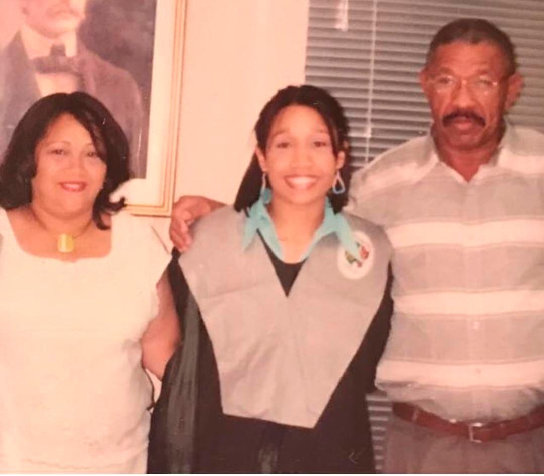 Michelle junto a sus padres el día de su graduación de la universidad. 