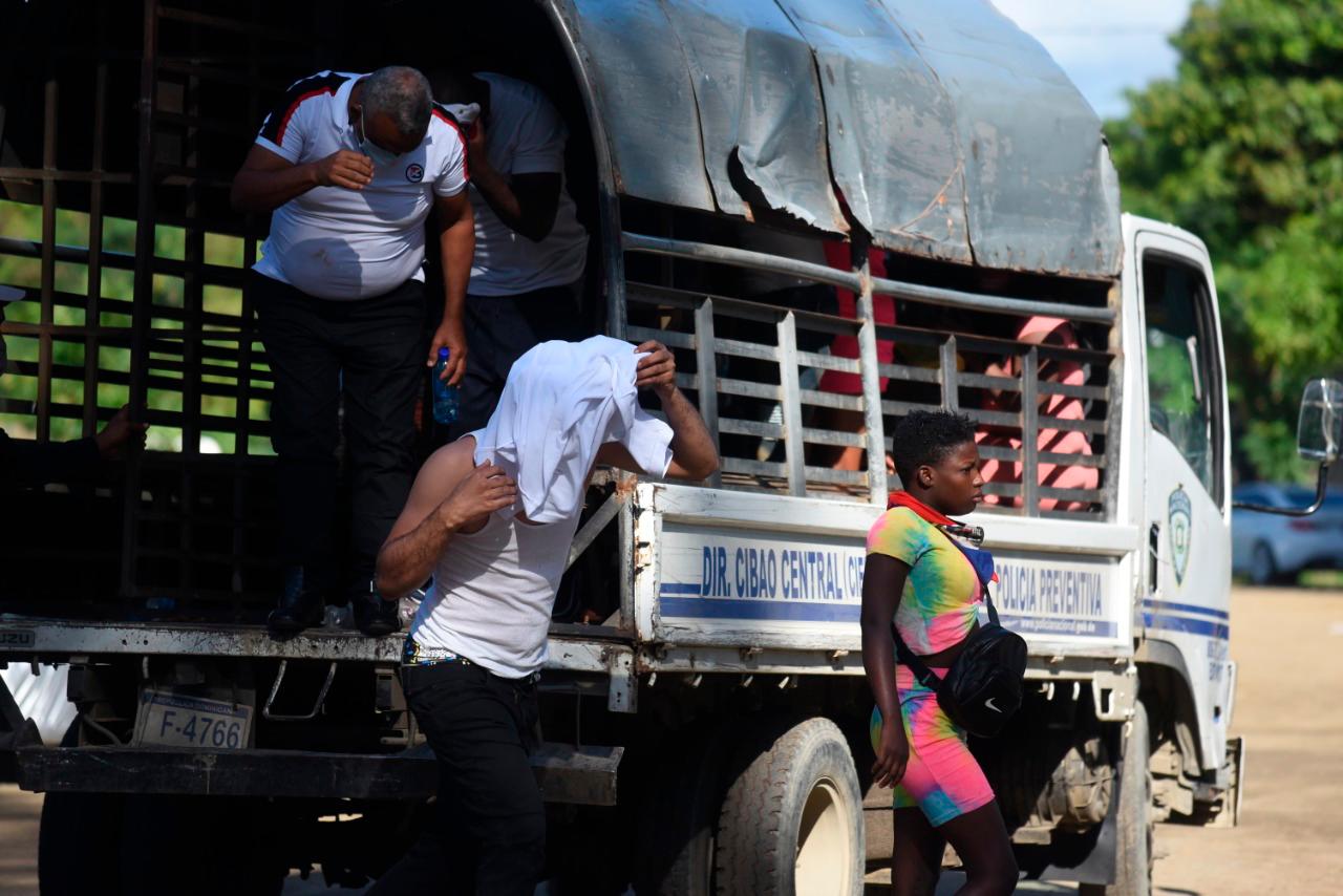 Personas que fueron detenidas bajando de un vehículo policial.