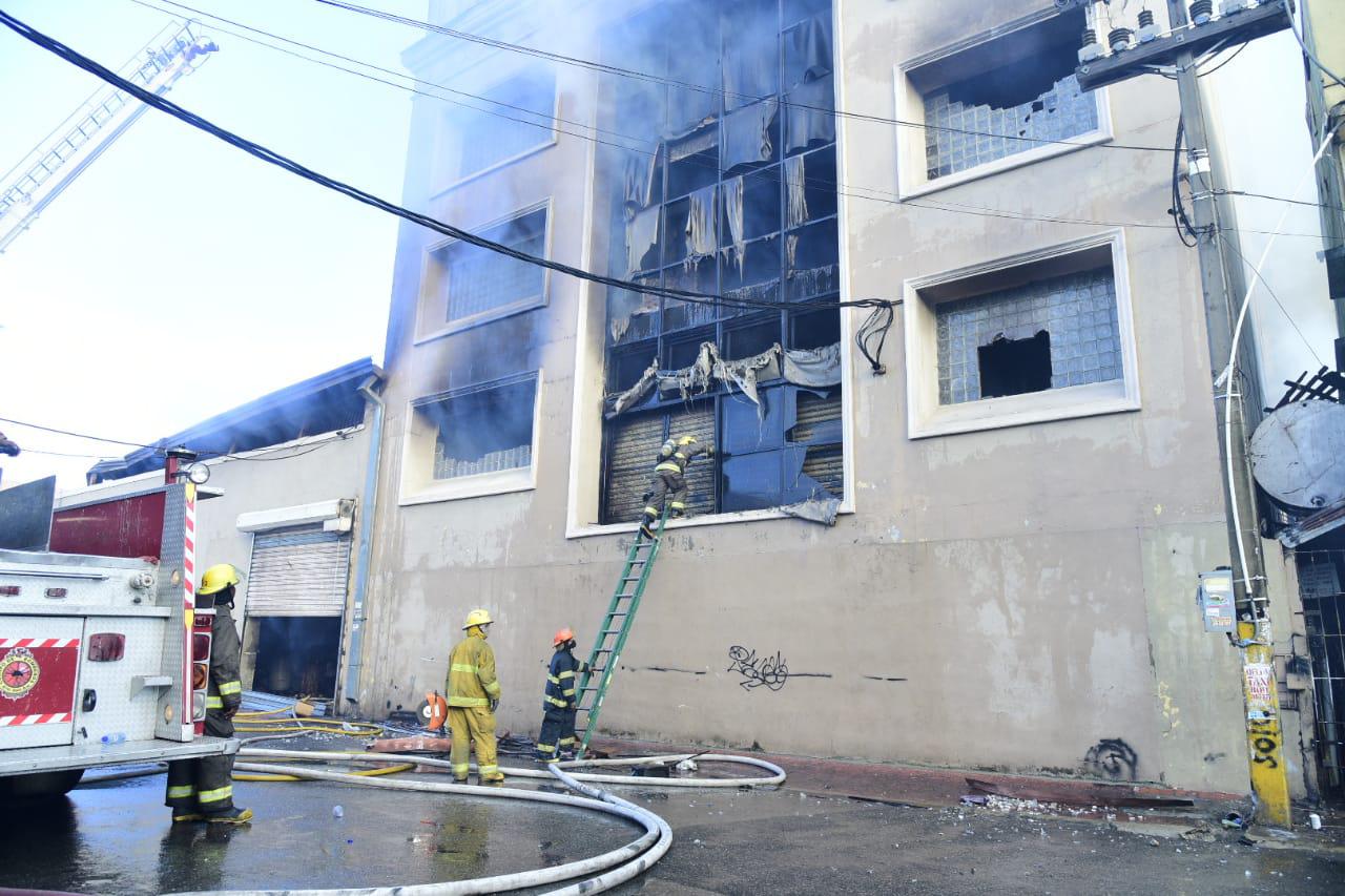 Un bombero escala la estructura consumida por el fuego en una fábrica de papel ubicada en Villa Juana (Eddy Vittini)