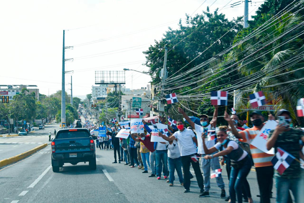 Personas apostadas en la ruta de Abinader.