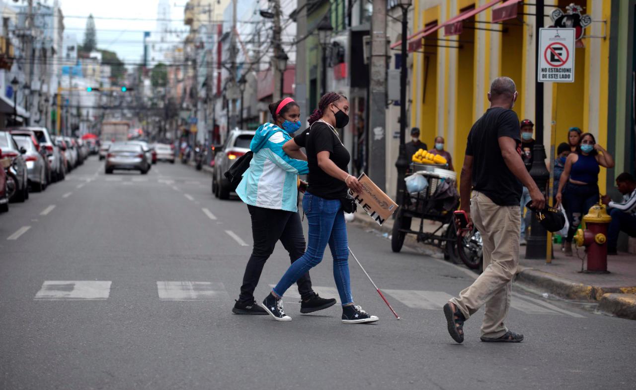 Una mujer ayudando a una con discapacidad visual.