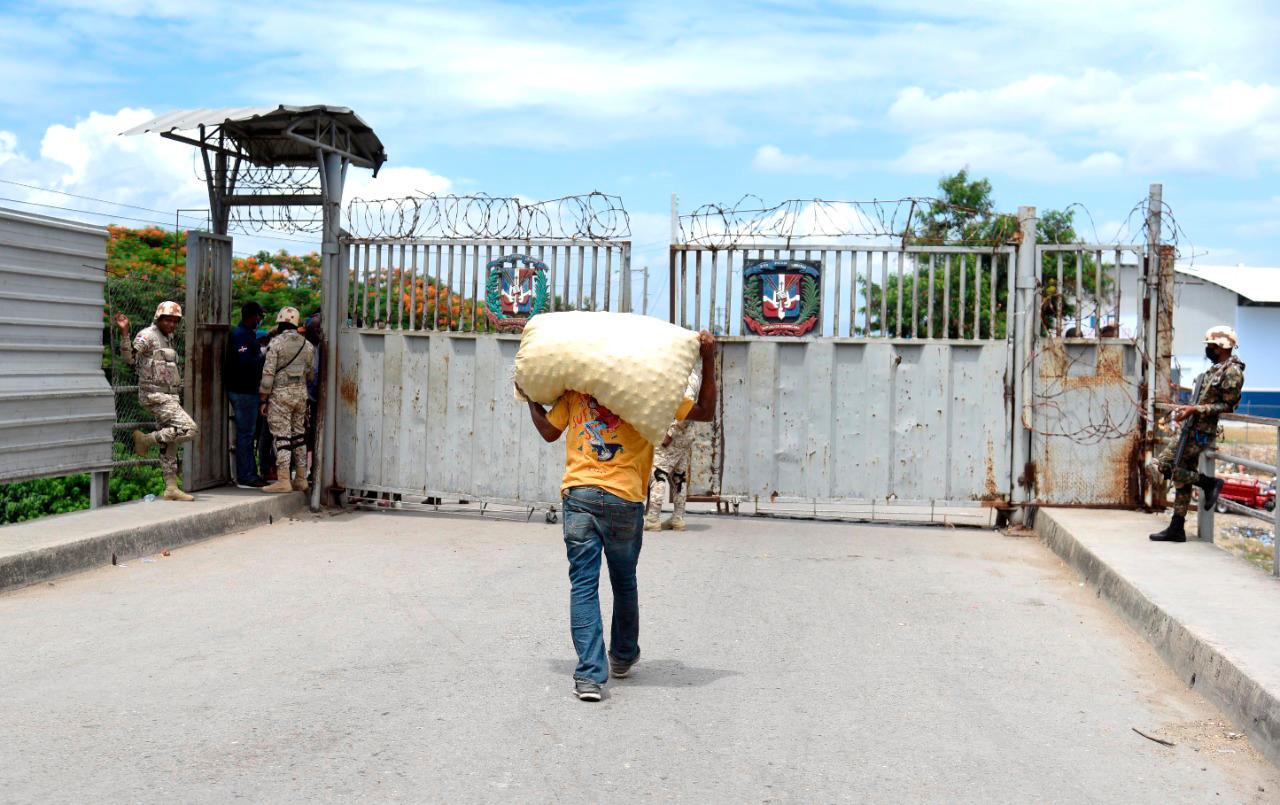 Un hombre cargando un saco en la frontera entre la República Dominicana y Haití.
