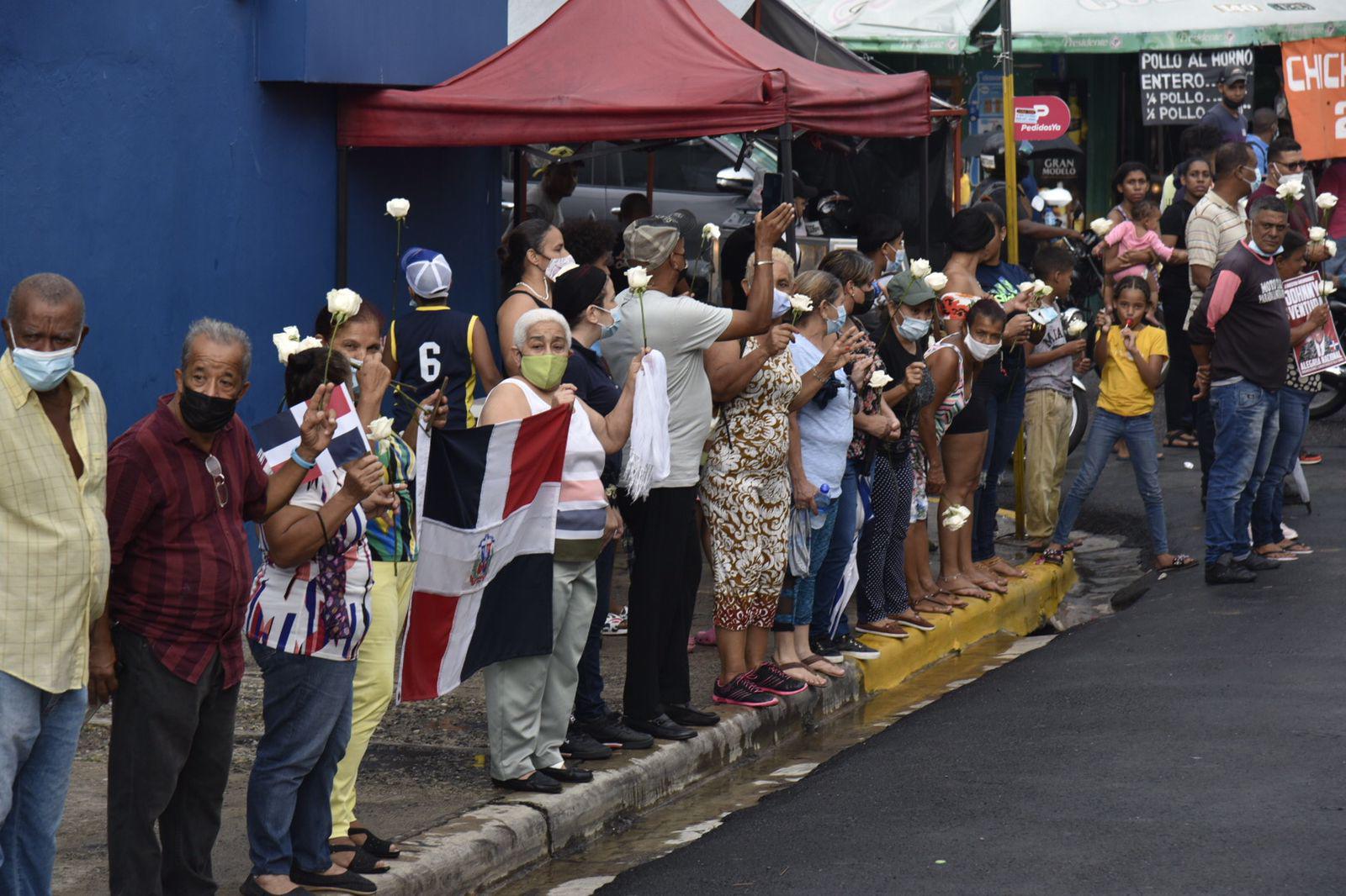 Con flores blancas y una bandera dominicana, los vecinos de Villa Juana esperaban el paso del cortejo fúnebre en el que se trasladaban los restos del inmortal Johnny Ventura (Foto: Neal Castro)