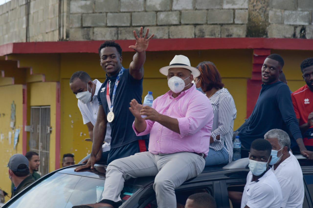 El pesista Zacarías Bonnat saluda durante un recorrido por su pueblo, Bayaguana, a su regreso con una medalla de plata en los Juegos Olímpicos, Tokio-2020. (DL/Dania Acevedo)