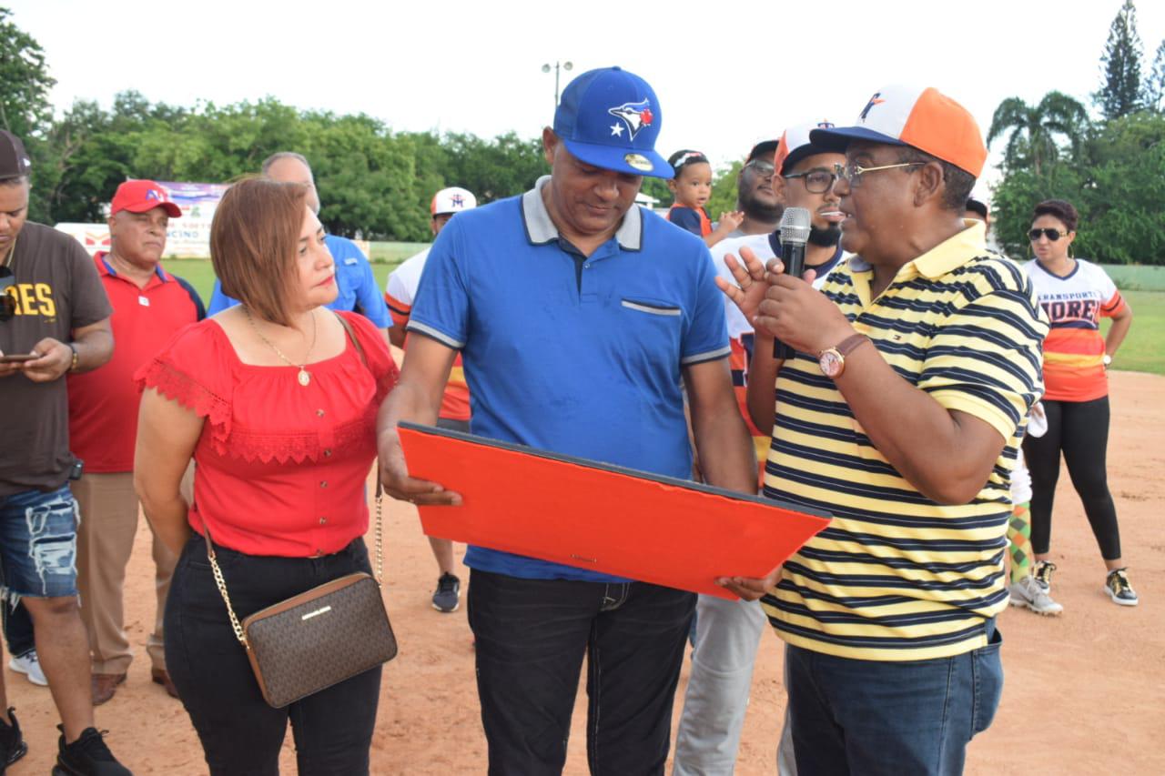 Miguel Ceballo (centro), recibe una placa de reconocimiento por la dedicatoria del II Clásico Transporte Morel de Softbol. Entrega Joselito Rodríguez, a la izquierda Minerva de Ceballo. (Fuente externa)