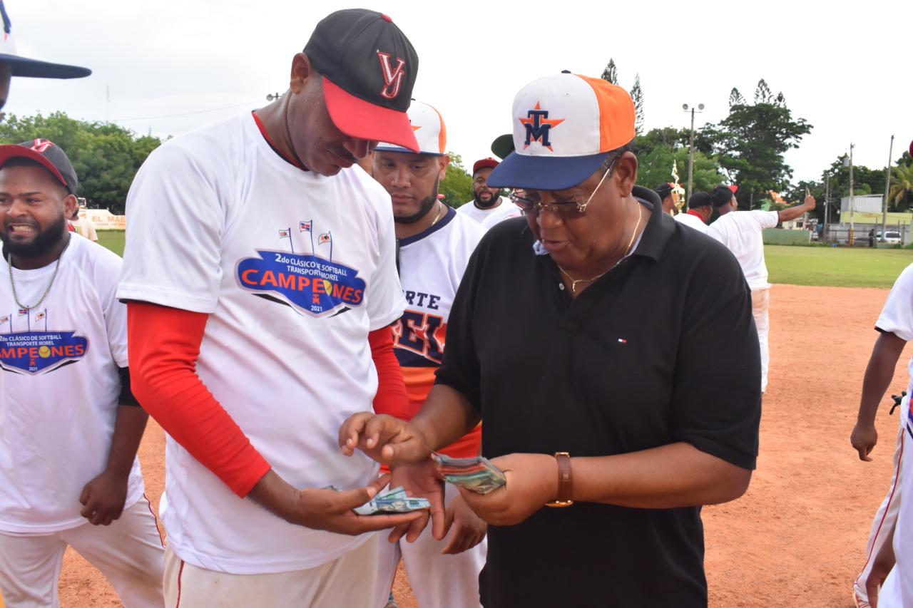 José Morel (derecha), entrega el premio de RD$100 mil al ex lanzador Roque Liriano, dirigente de Villa Juana. (Fuente externa)