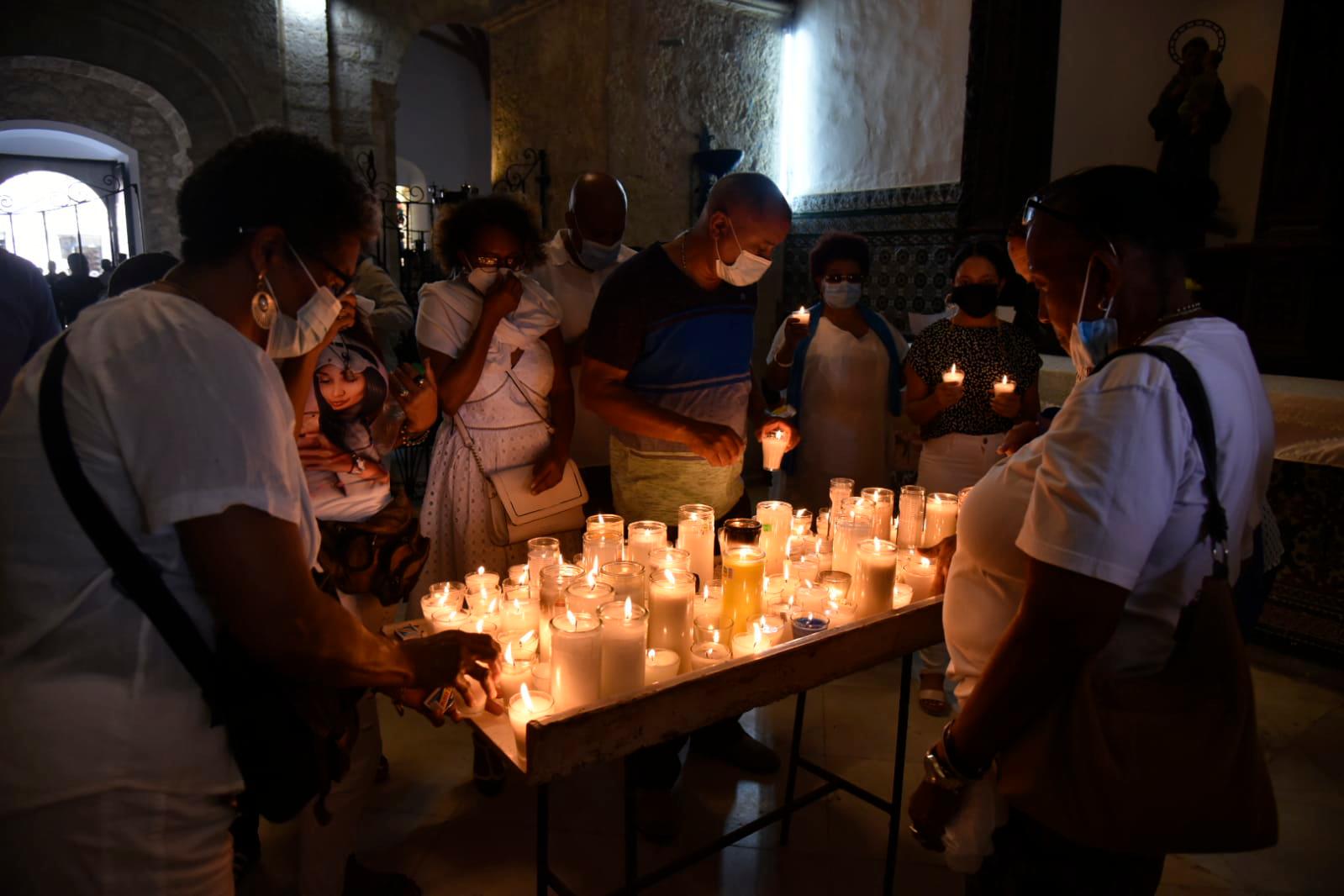 Personas colocando velones a la Virgen de las Mercedes en una de las capillas laterales de la iglesia de Las Mercedes, en la Ciudad Colonia.