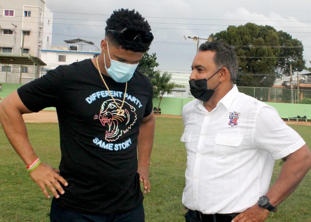 Quilvio Veras, derecha, explica a Juan Soto los proyectos de la Oficina del Comisionado de Béisbol de Pequeñas Ligas, en la inauguración del torneo de béisbol infantil en la liga los Vecinitos del ensanche Luperón. (Prensa/Cobepeli)