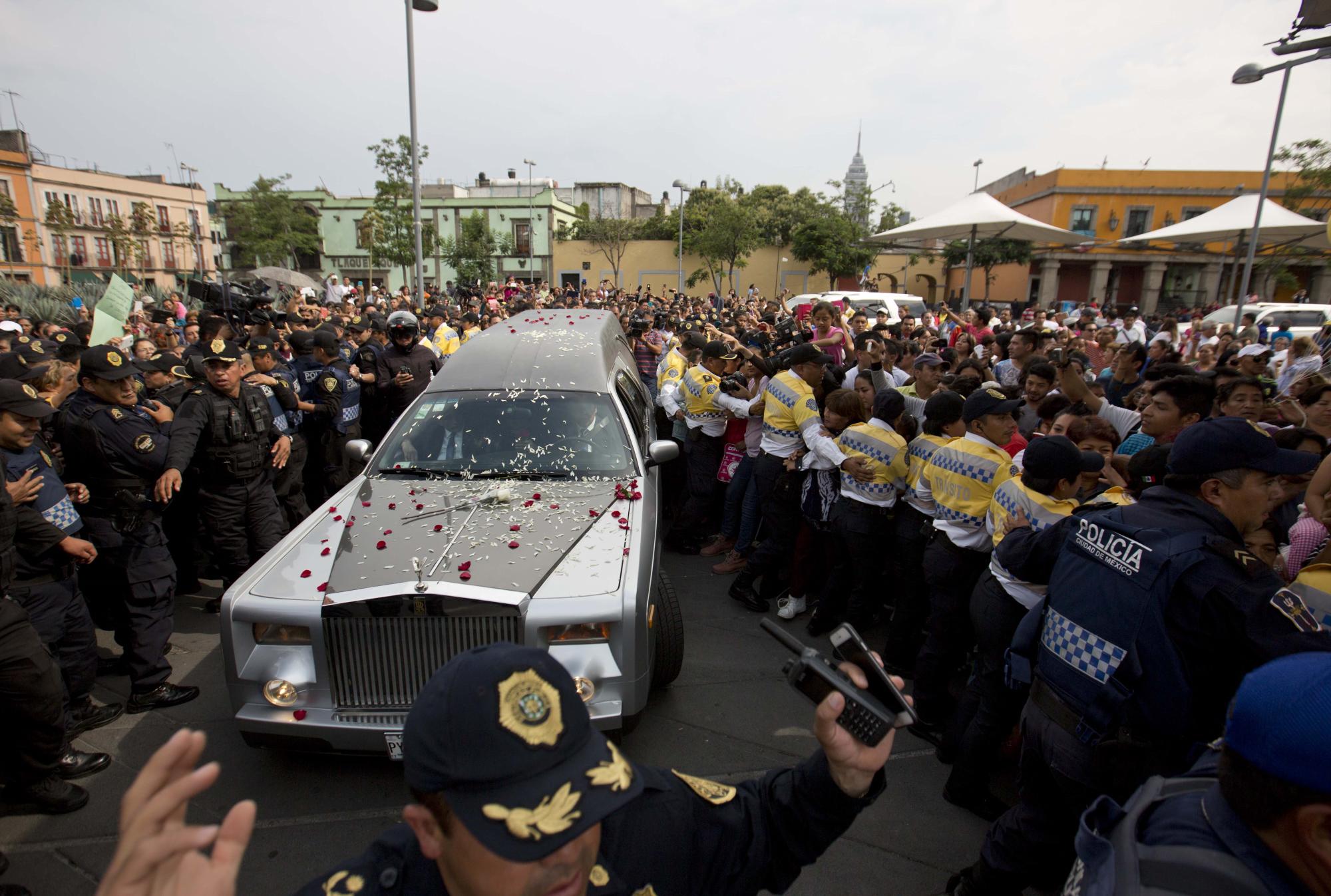 Una carroza fúnebre con los restos del cantante mexicano Joan Sebastian recorre la Plaza Garibaldi durante una procesión funeral en la Ciudad de México, el jueves 16 de julio del 2015. El músico murió el lunes tras una larga lucha con el cáncer, a los 64 años.