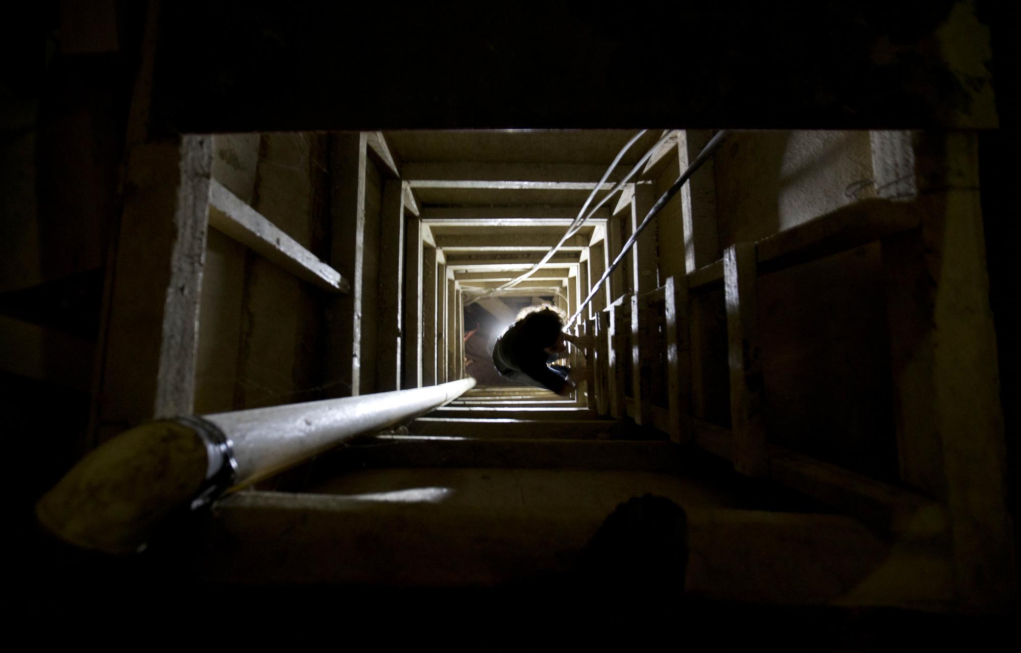 En esta imagen del martes 14 de julio de 2015, un periodista trepa por una escalera para salir del túnel por el que, según las autoridades, escapó el capo de la droga Joaquín El Chapo Guzmán de la prisión de máxima seguridad de Altiplano, en Almoloya, al oeste de la ciudad de México.  