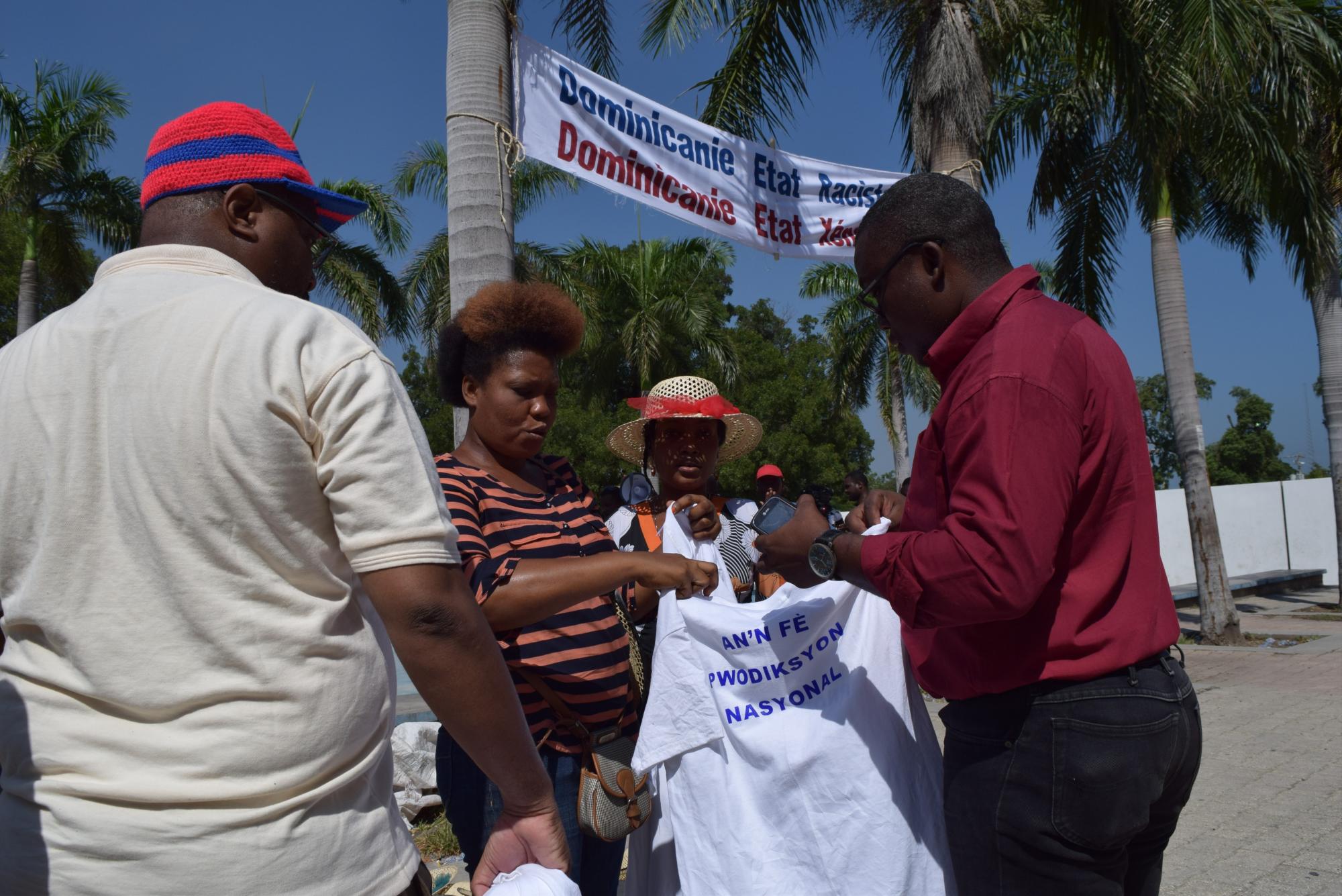 Manifestantes distribuyen camisetas durante marcha.