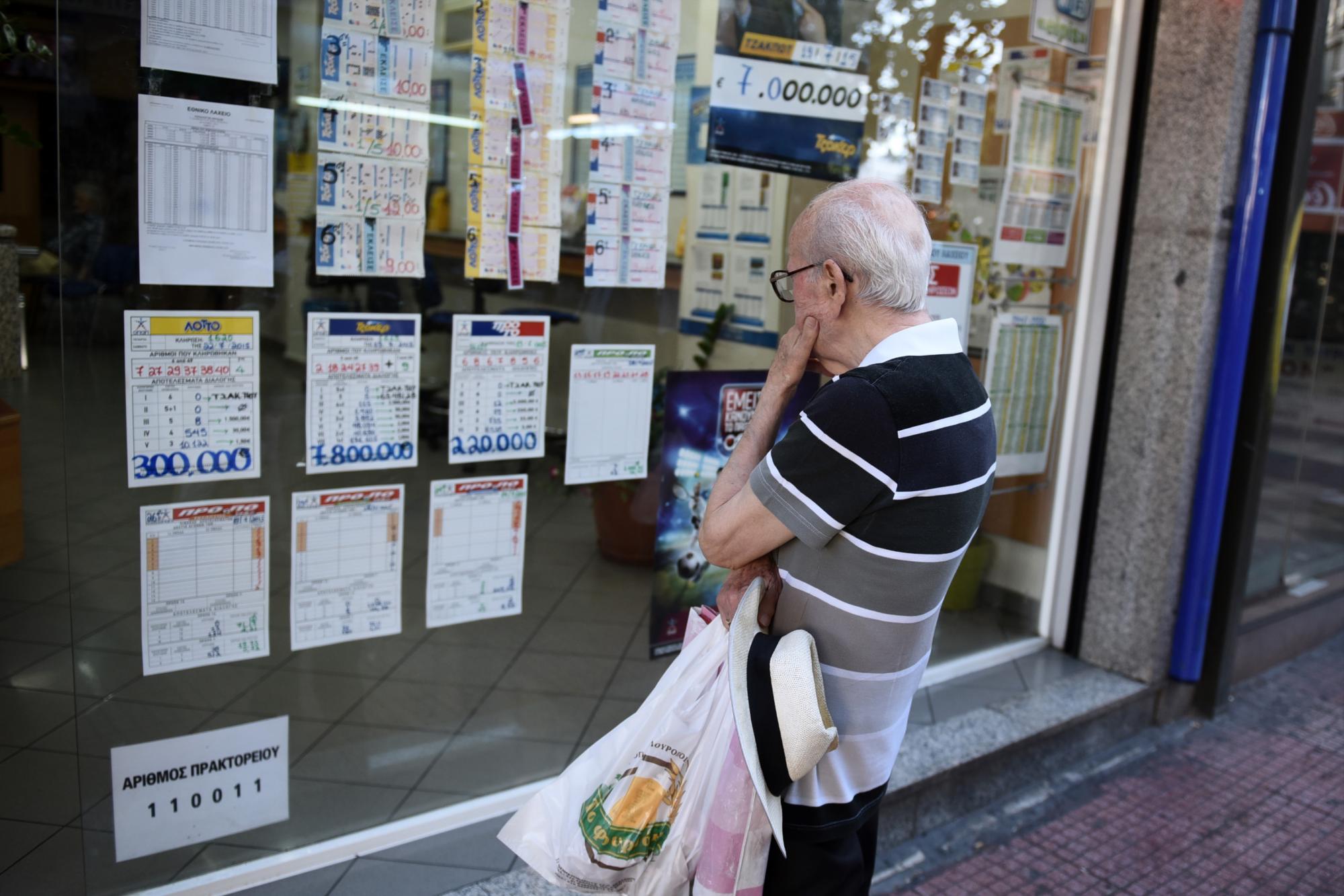 Un anciano observa los números ganadores de la lotería en un local en Atenas, Grecia, el 23 de julio de 2015. 