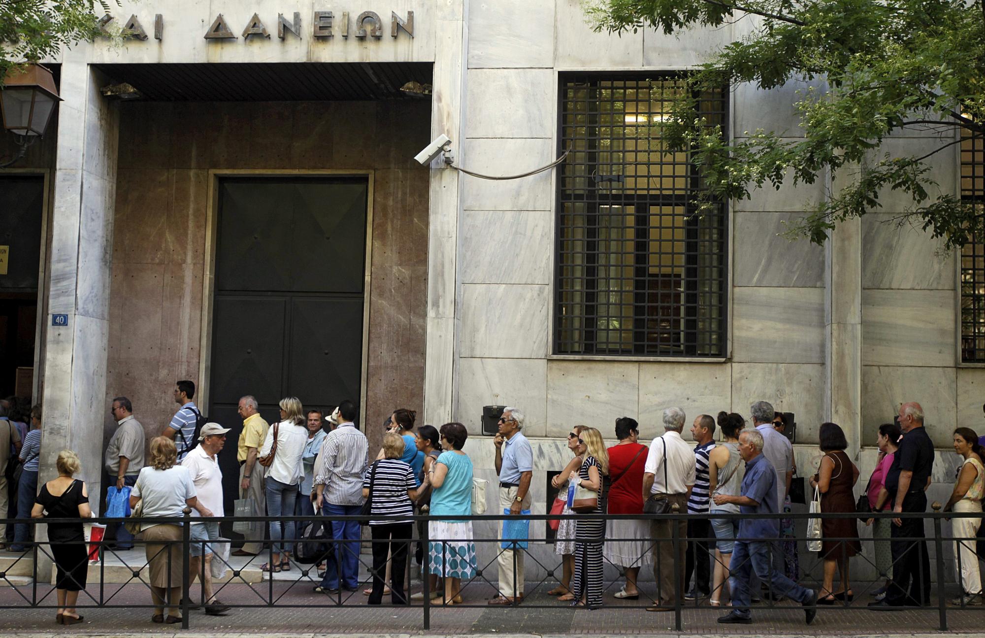 Un grupo de personas hace cola para realizar sus transacciones en el Fondo de Depósitos y Préstamos en Atenas (Grecia) hoy, 24 de julio de 2015. 