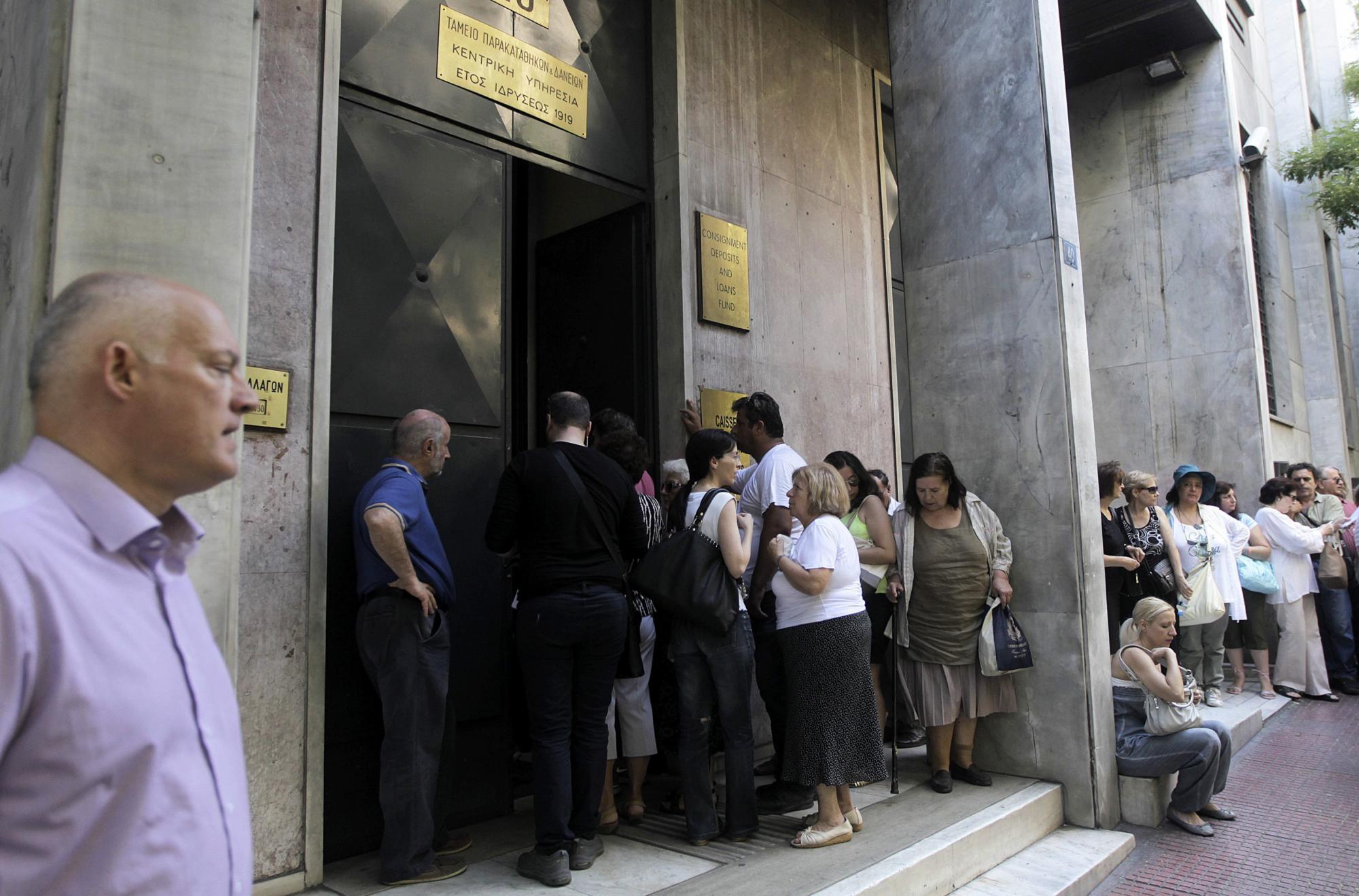 Un grupo de personas hace cola para realizar sus transacciones en el Fondo de Depósitos y Préstamos en Atenas (Grecia) hoy, 24 de julio de 2015.