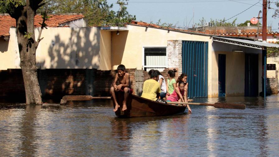 Canoas y refugios cambian el paisaje de los barrios inundados de Asunción