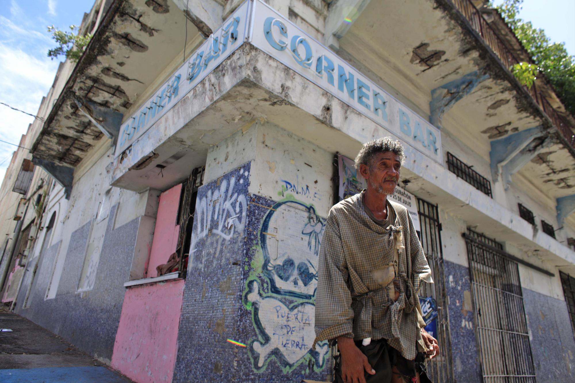 Un hombre sin hogar ante un establecimiento cerrado en puerta de Tierra, a las afueras del Viejo San Juan, en Puerto Rico, el domingo 2 de agosto de 2015.