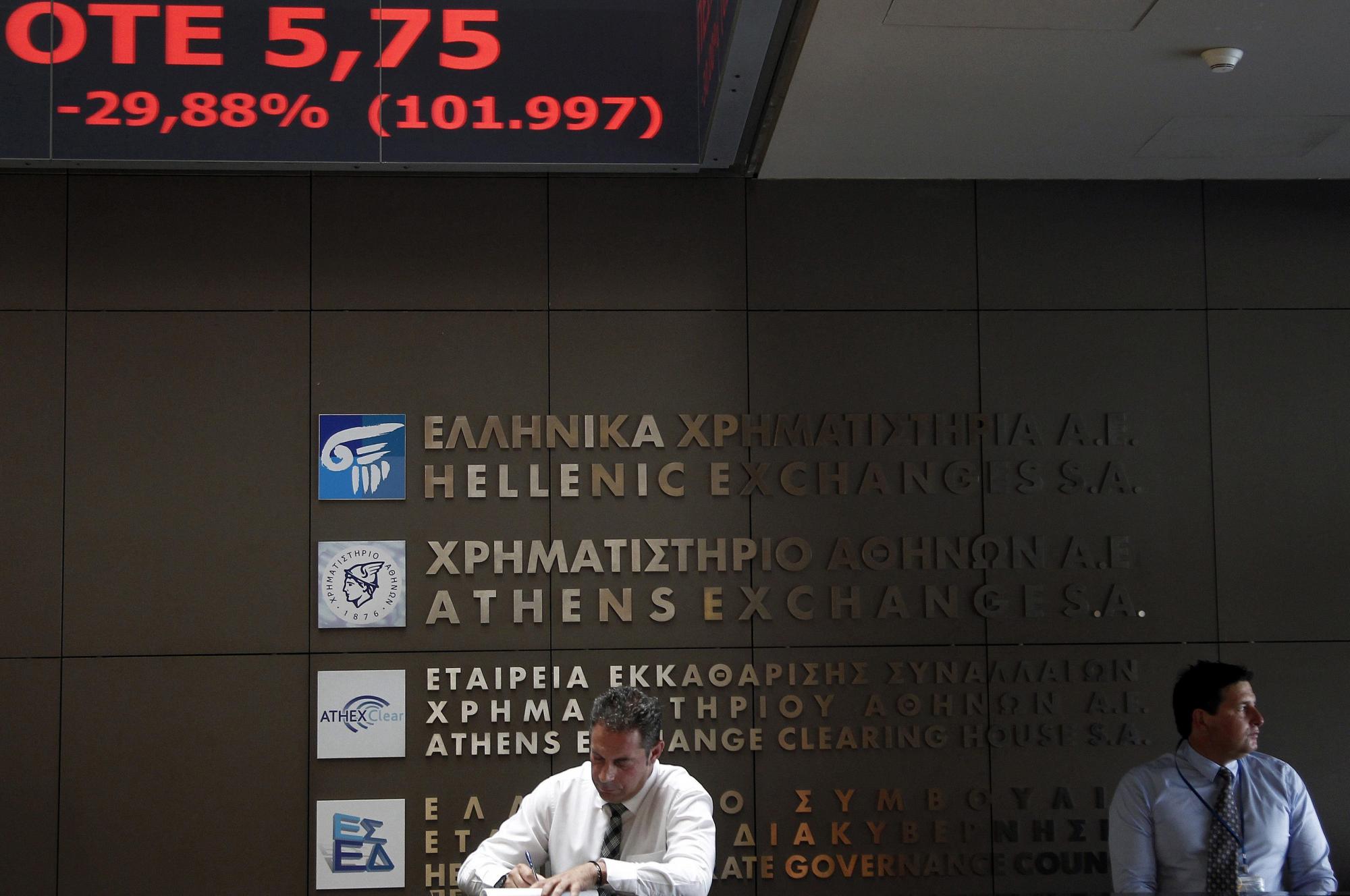 Agentes de Bolsa realizan su trabajo en el parqué de Atenas en Grecia hoy, lunes 3 de agosto de 2015. La Bolsa de Atenas reabrió hoy, tras cinco semanas de clausura, con un desplome de cerca del 22 %.  