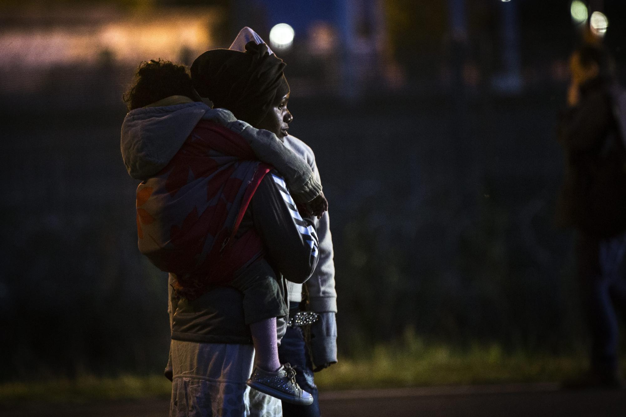 Una migrante eritrea con su hijo mientras espera la oportunidad de burlar las rejas de seguridad luego que la policía francesa los expulsara a las afueras de Calais (Francia).