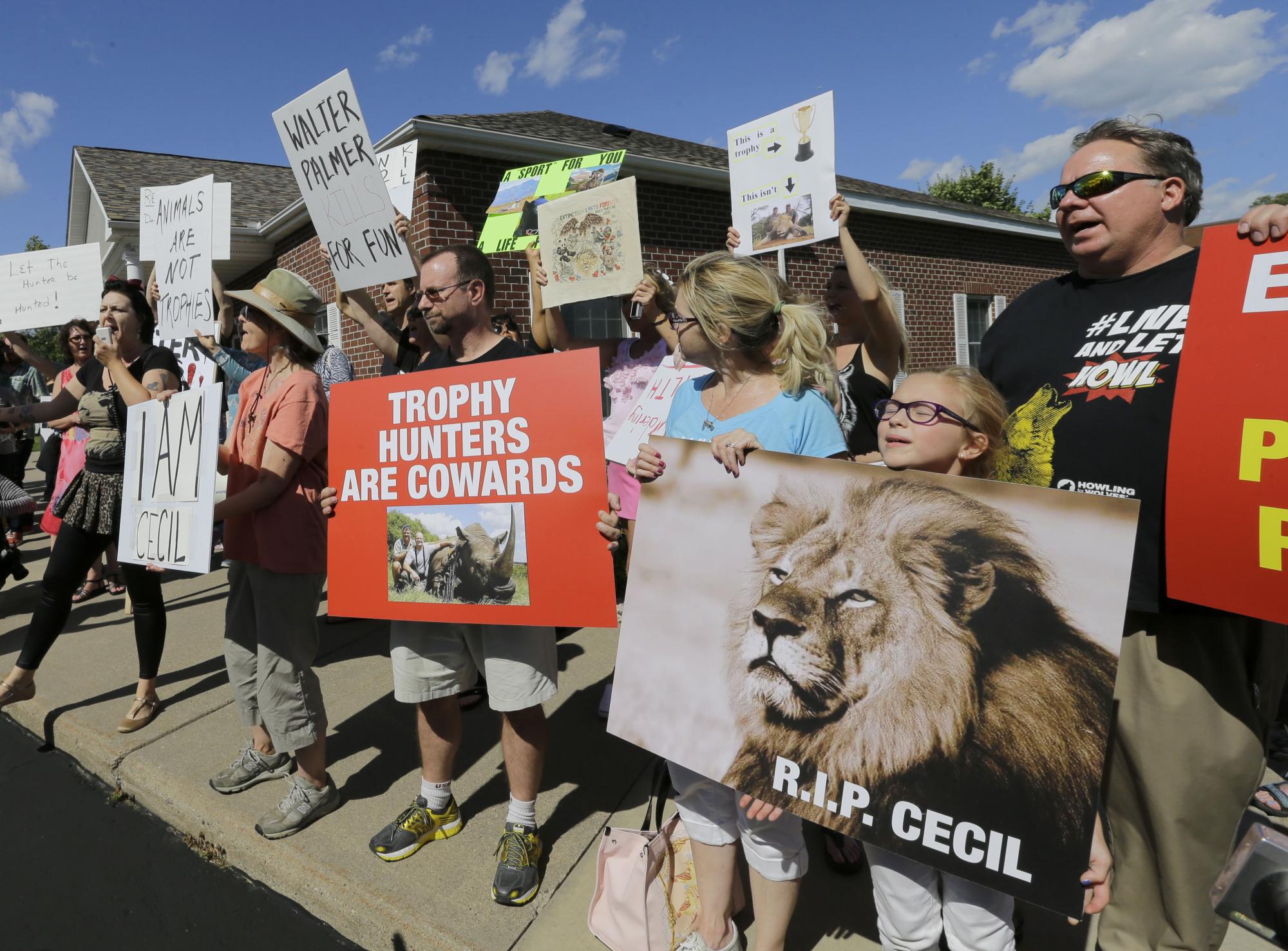 Manifestantes se congregan frente al consultorio del dentista Walter James Palmer en Bloomington, Minnesota, por haber matado a un león en Zimbabue.