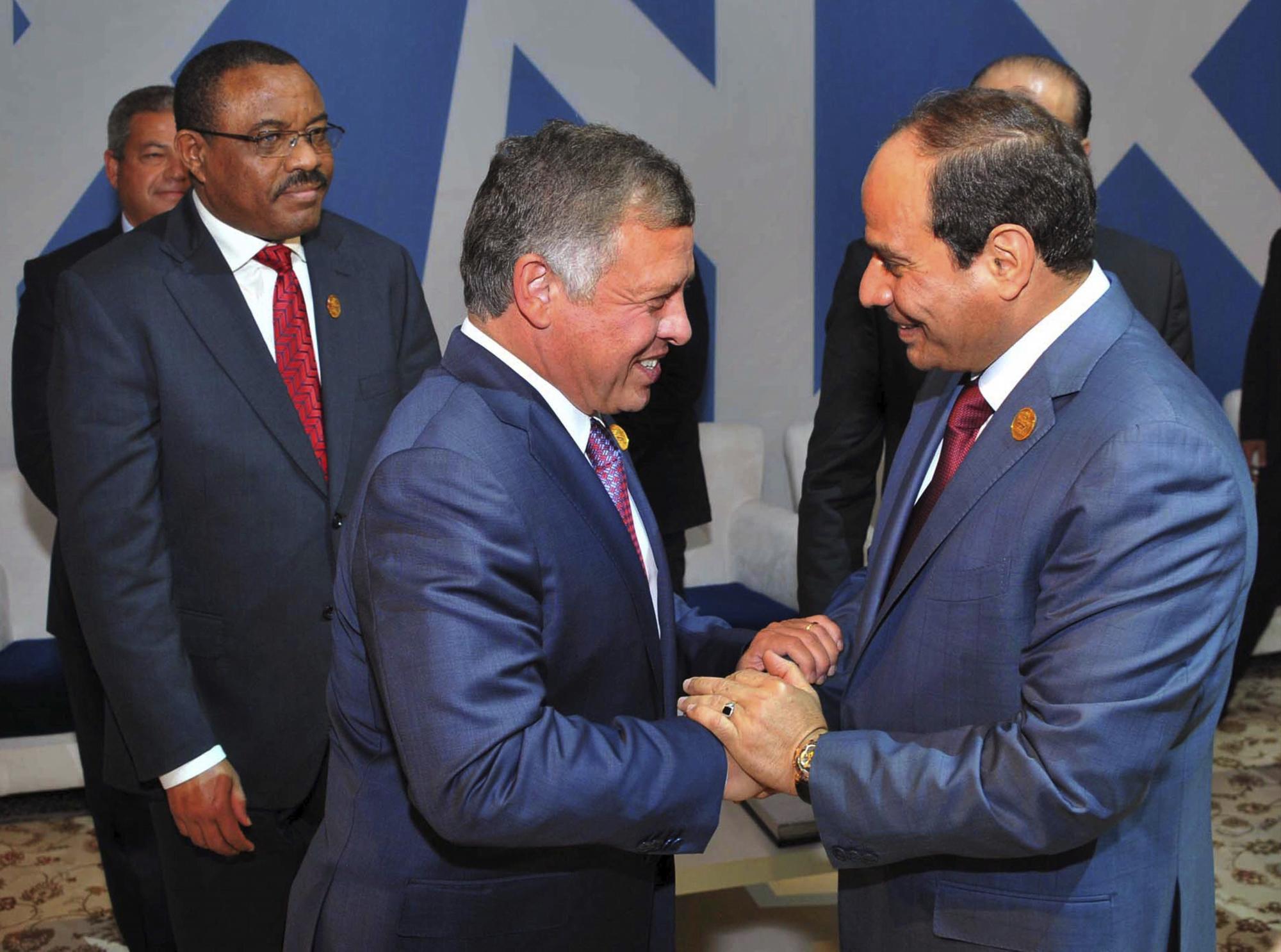Fotografía facilitada por la presidencia egipcia que muestra a su titular Abdelfatah al Sisi (d) saludando al rey Abdalá II de Jordania (i).