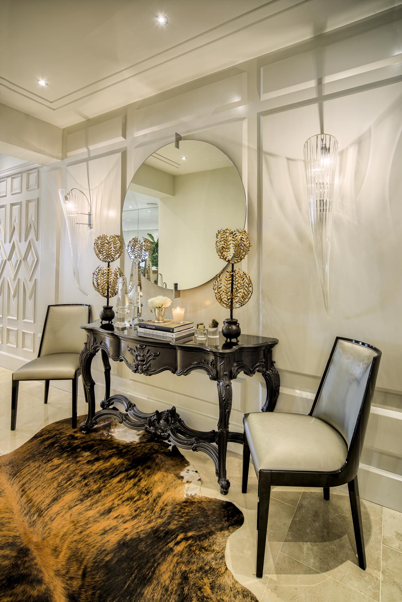 Con luminarias de acento, un trabajo en paneles y la disposición de piezas que desvelan con garbo lo que se apreciará en el resto de la composición del apartamento.