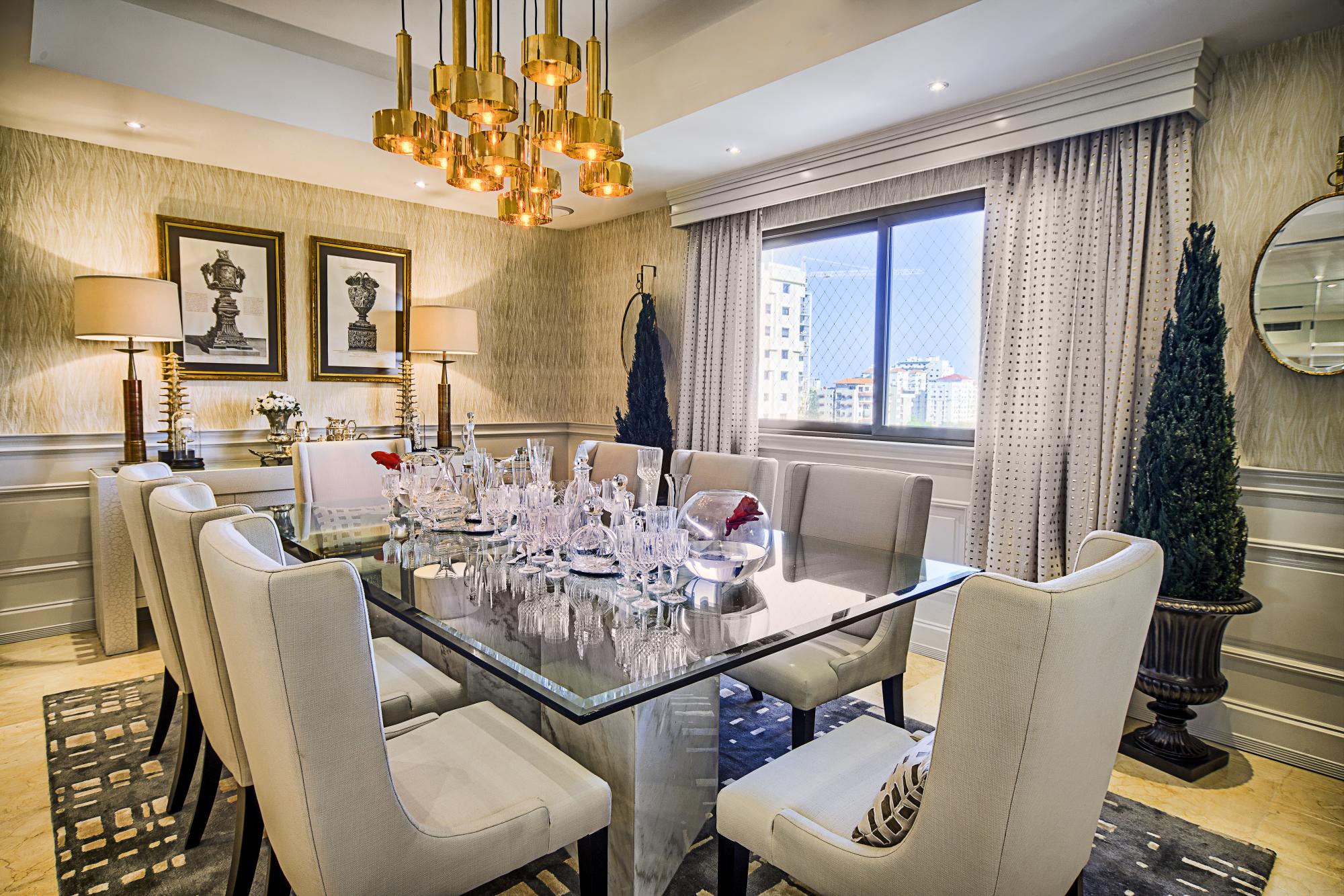 En el comedor se percibe el aire clásico y conservador. Sin embargo, detalles en tonalidad cobriza, dorada y plateada; así como una mesa con un vidrio flotante en cimientos marmóreos, modernizan todo.