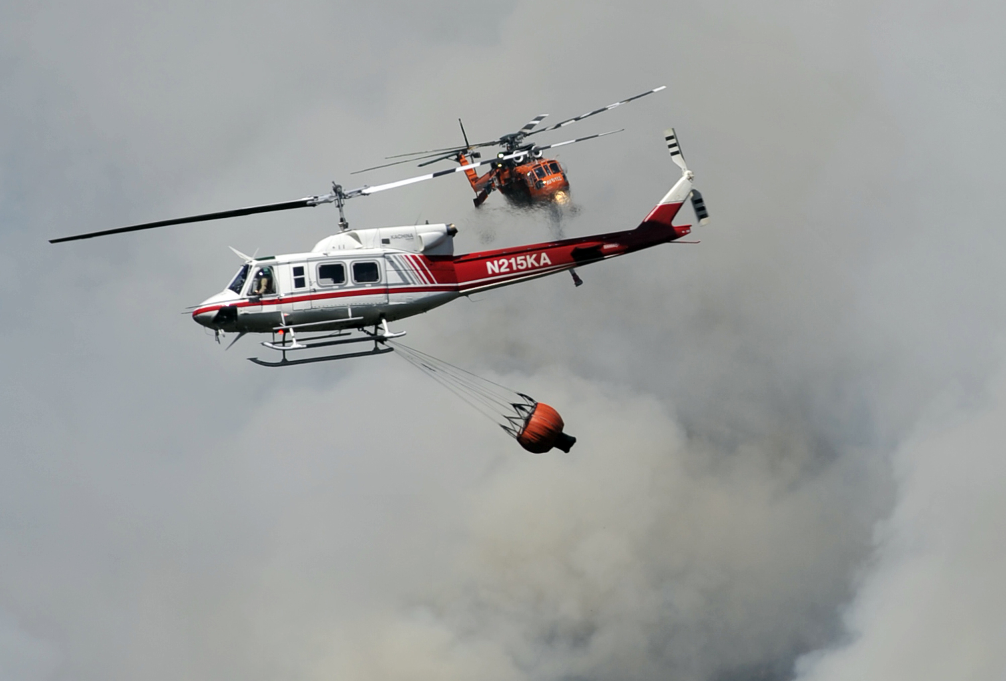 Dos helicópteros antincendios maniobran sobre el cañón Willow Creek debido a un fuego forestal cerca de Bass Lake, California, el lunes 27 de julio de 2015. El incendio amenazaba el martes unas 450 viviendas y otros inmuebles en las escarpadas faldas de las montañas del norte de California, según las autoridades.