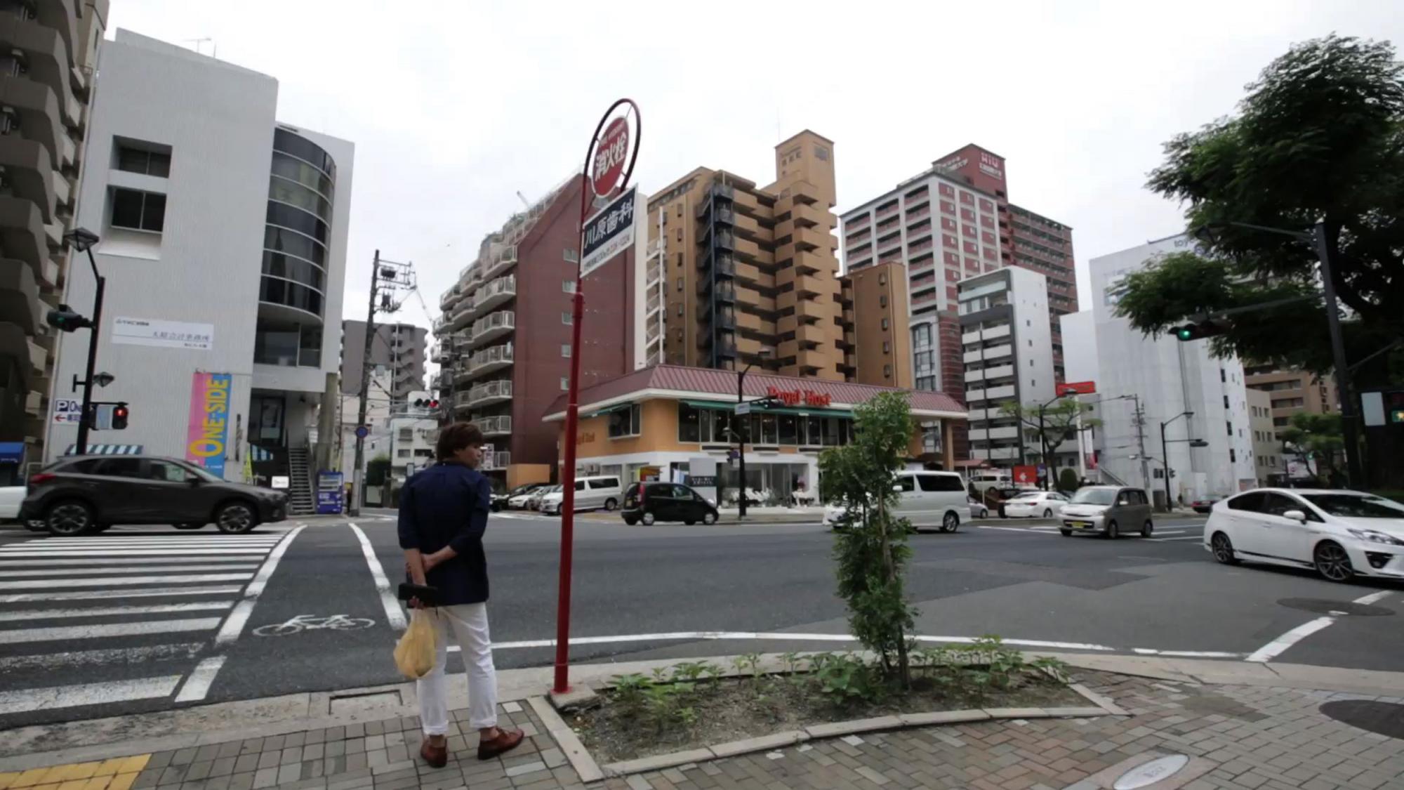 En esta imagen, tomada el 5 de julio de 2015, un hombre espera en un cruce a unos 2 kms (1,2 millas) al noroeste de lo que ahora se conoce como la Cúpula de la Bomba Atómica en Hiroshima.