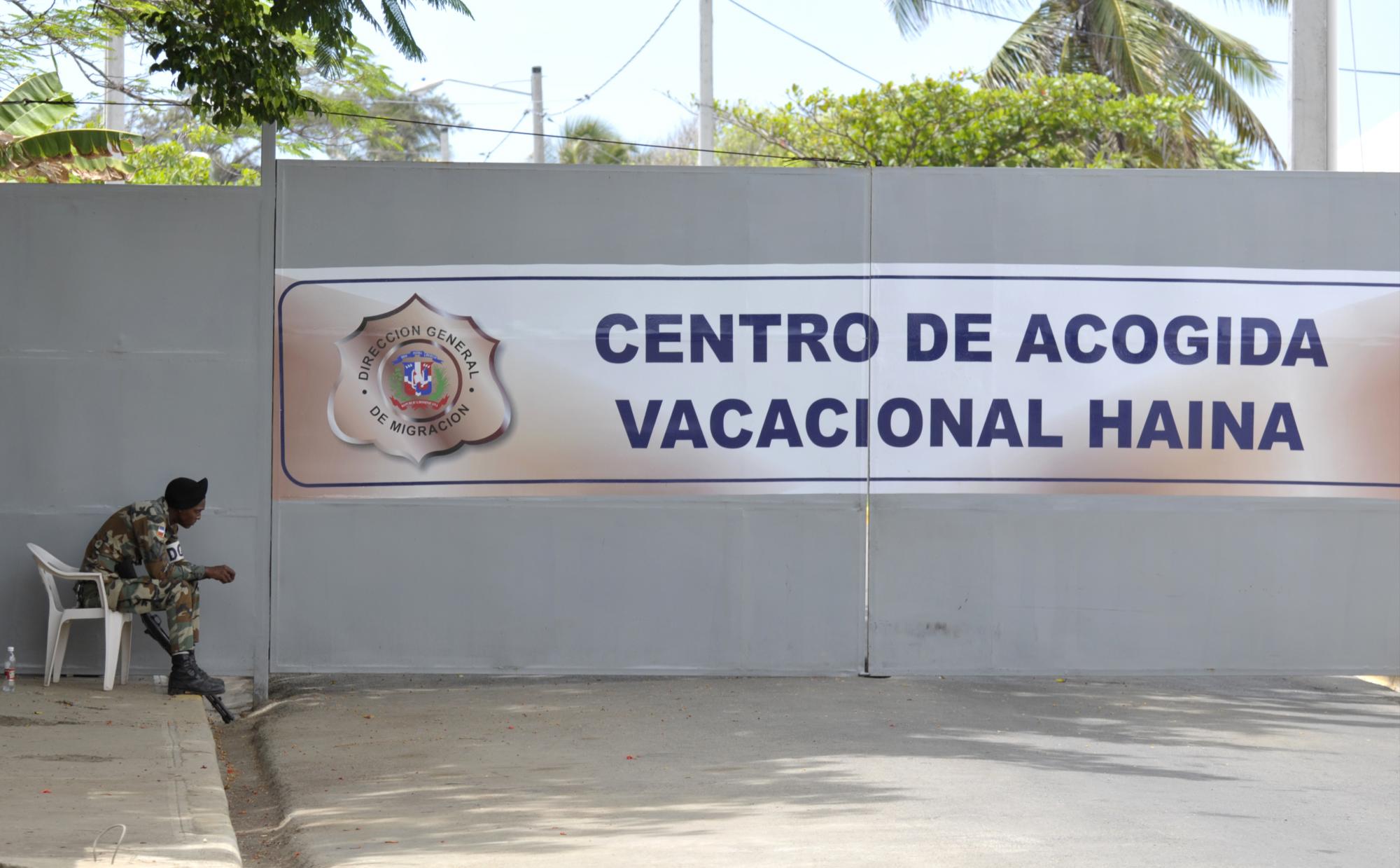 Un militar resguarda la entrada hacia el Centro de Acogida Vacacional de Haina, a donde son conducidos los extranjeros para el proceso de depuración de su situación legal. 