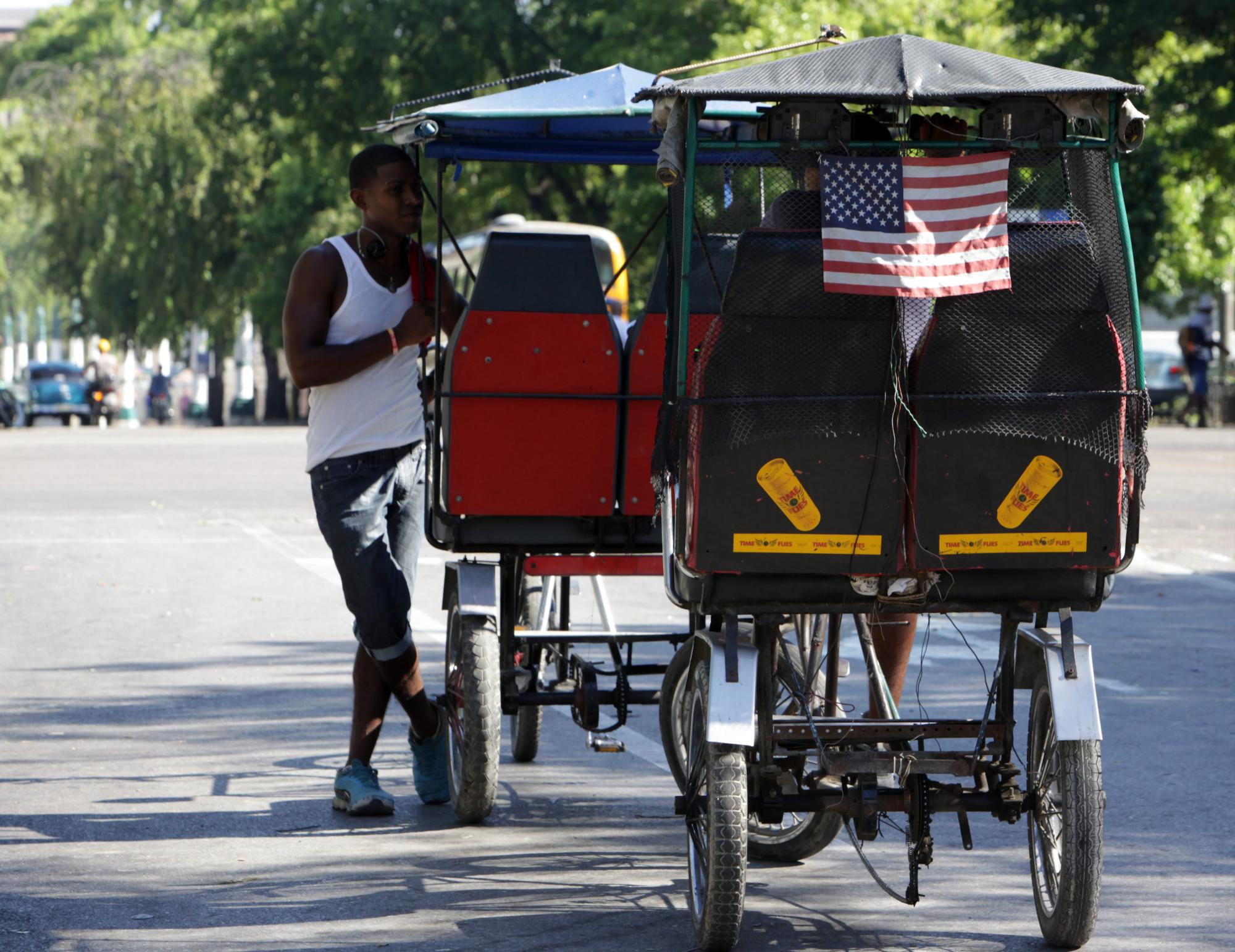 Dos cubanos hablan en unos bicitaxis el 15 de agosto de 2015, en La Habana (Cuba). 