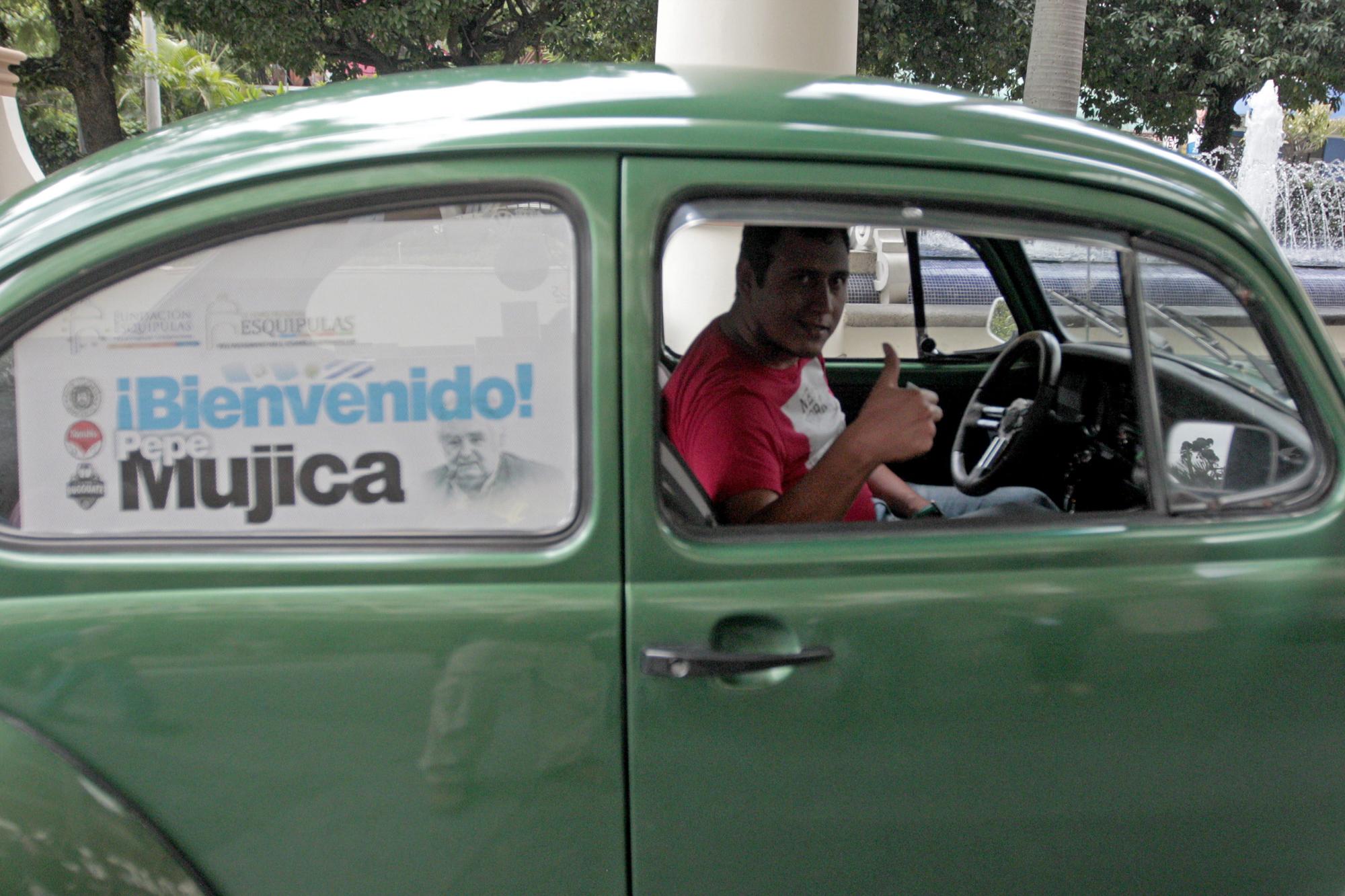 Un conductor de Escarabajo Volkswagen muestra su apoyo al expresidente de Uruguay José Mujica, quien arribó a Guatemala, para asistir al Foro Regional Esquipulas 2015, en Ciudad de Guatemala.