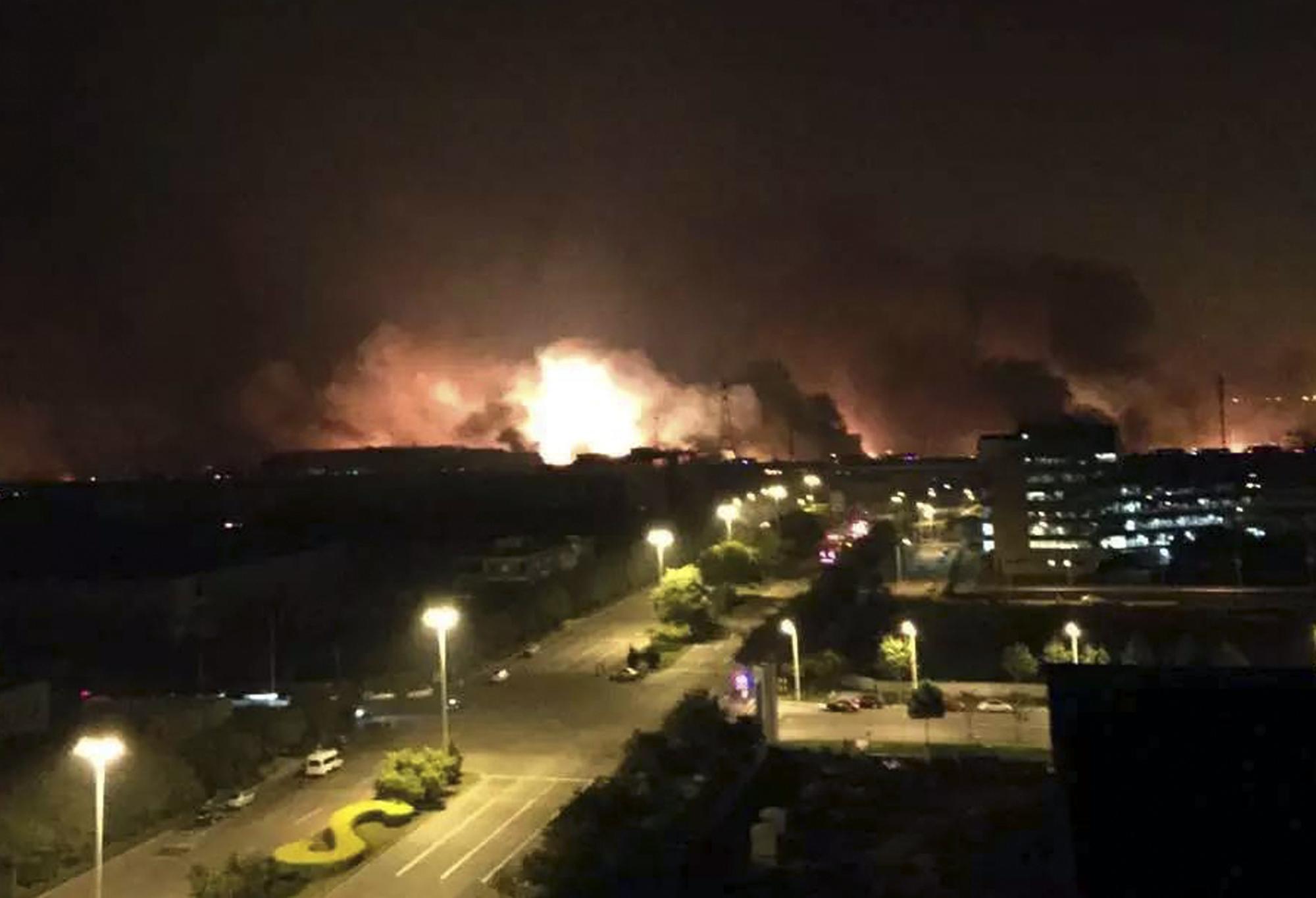 En esta foto distribuida por la Agencia Noticiosa Xinhua, se ve el humo y el fuego a través de la noche tras una explosión en la Nueva Área Binhai en el norte del municipio de Tianjin, en China el jueves 13 de agosto de 2015. 
