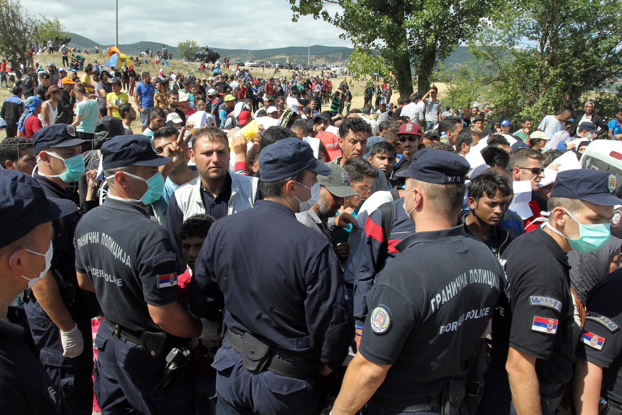 Los miembros de las fuerzas policiales Serbia montan guardia en un centro temporal para refugiados en la frontera entre Serbia y Macedonia , cerca de la aldea de Miratovac , el sur de Serbia, el 23 de agosto de 2015.