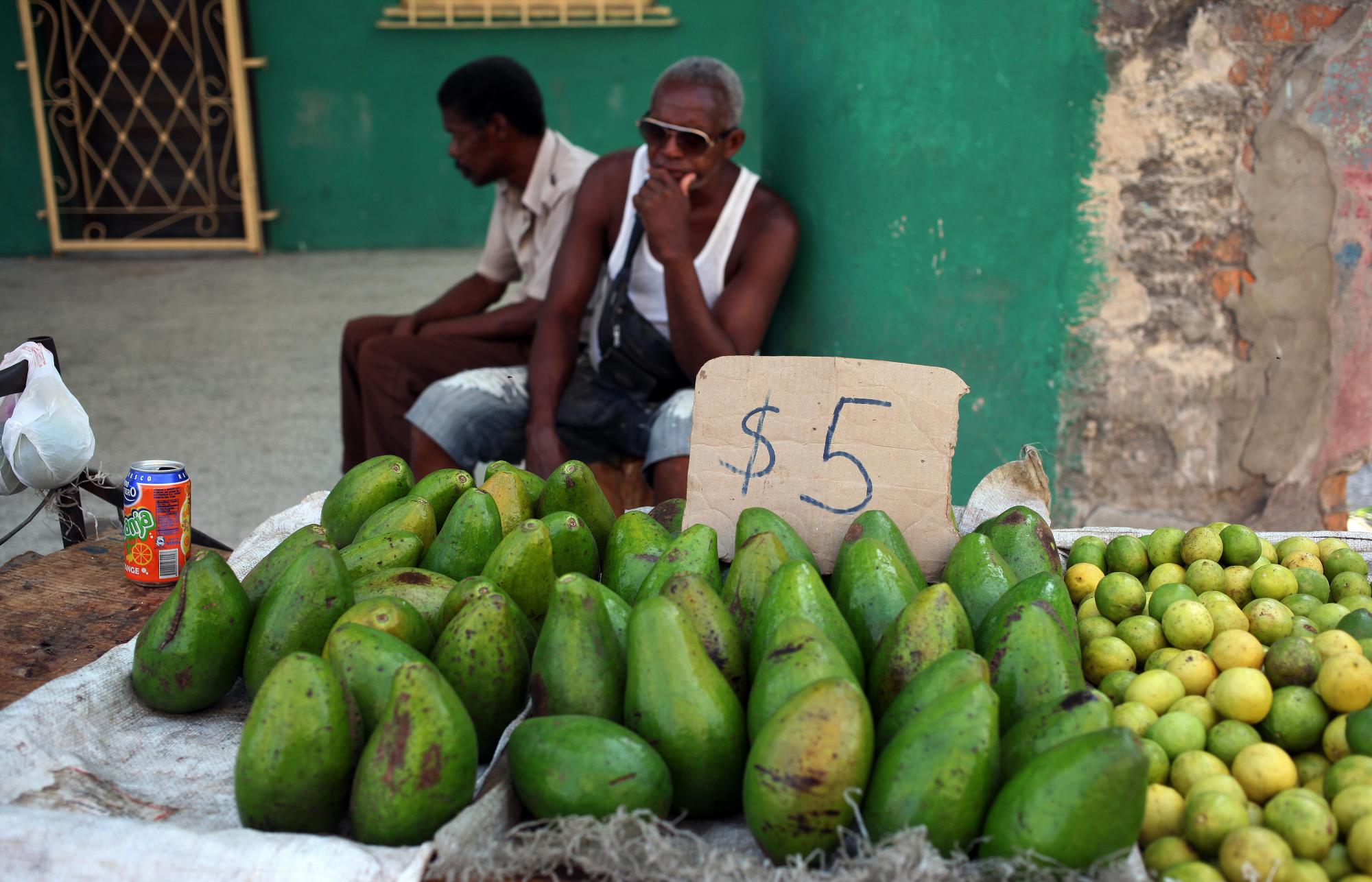 Un trabajador por cuenta propia vende aguacates y limones en una carretilla el 25 de agosto de 2014, por una calle de La Habana (Cuba).