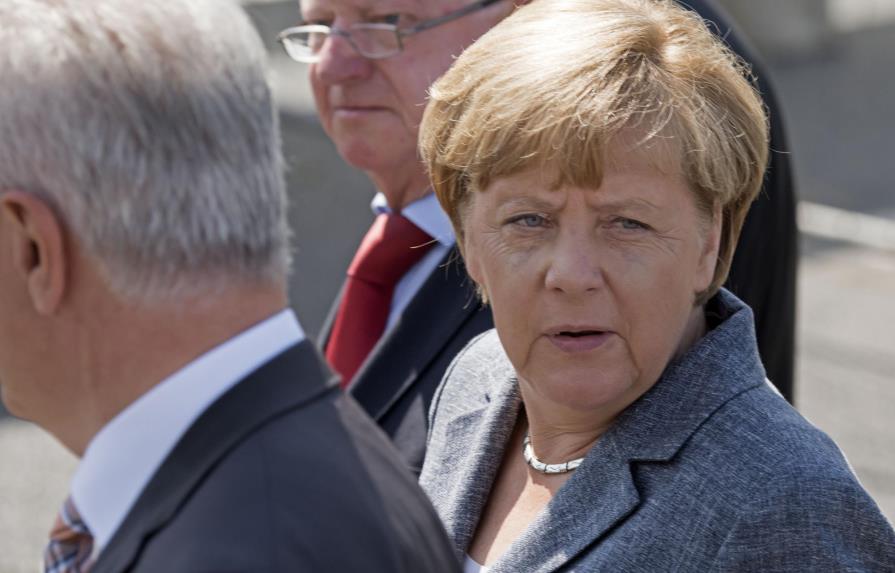 Merkel, abucheada por vecinos al visitar un centro de refugiados atacado