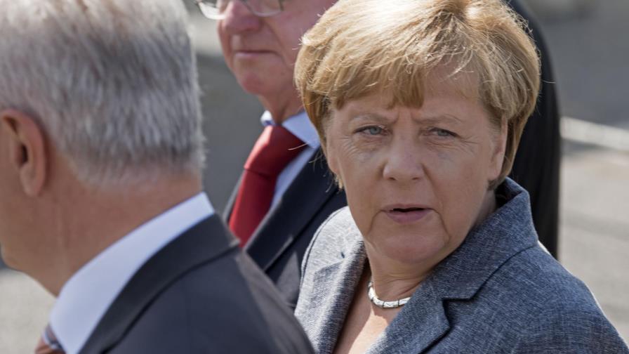 Merkel, abucheada por vecinos al visitar un centro de refugiados atacado