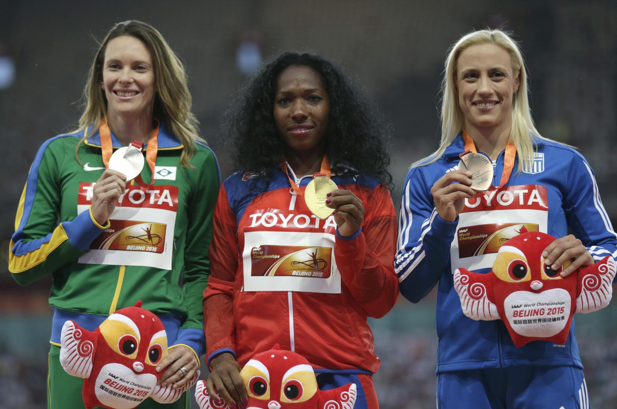 La brasileña Fabiana Murer, plata y la cubana Yarisley Silva, medalla de oro y la griega Nikoleta Kyriakopoulou, bronce, durante la entrega de medallas de la prueba de salto con pértiga, dentro del Campeonato del Mundo de Atletismo, que se celebra en el estadio del Nido del Pájaro, en Pekín. 