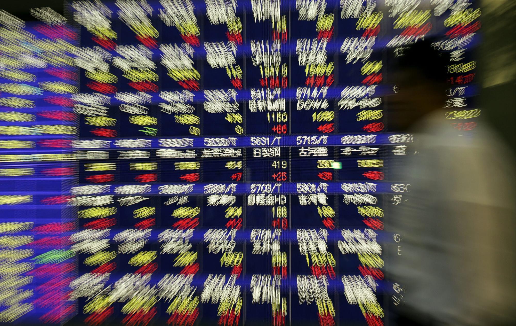 Un hombre observa la información bursátil mostrada en unas pantallas en Tokio. El índice Nikkei de la Bolsa de Tokio cerró hoy con una subida de 561,88 puntos-