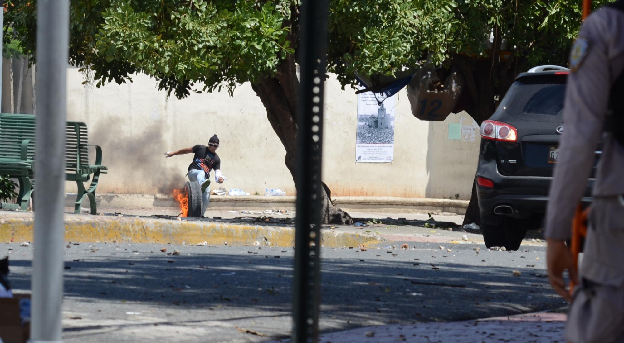 Un estudiante se defiende de una bomba lacrimógena